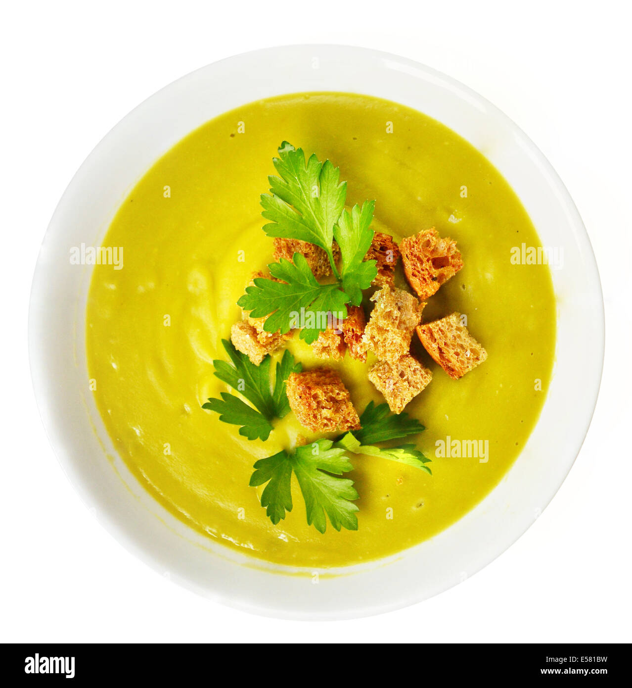 cream soup with dried crusts and green parsley Stock Photo