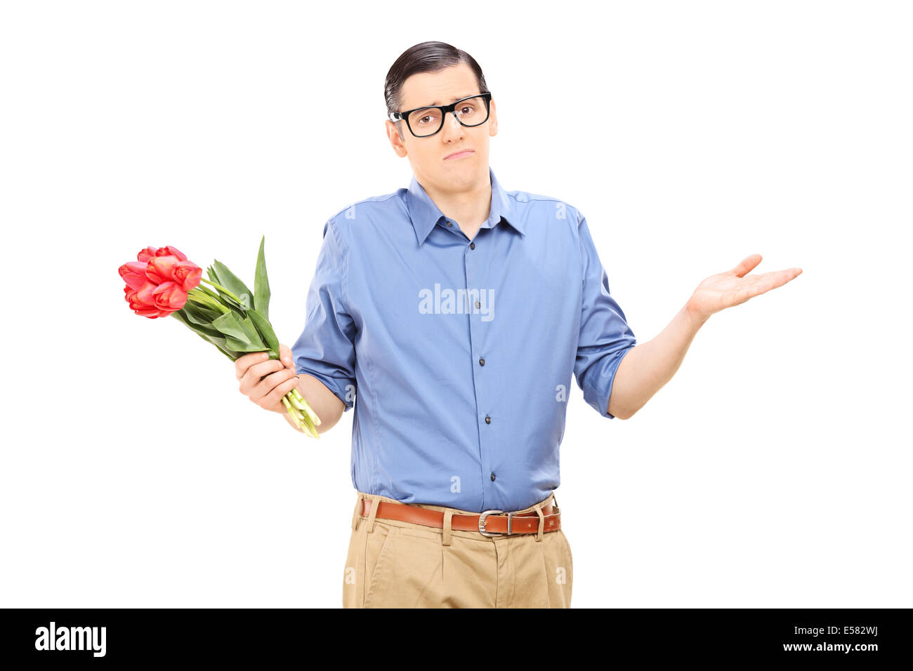 Displeased young man holding a bunch of flowers Stock Photo