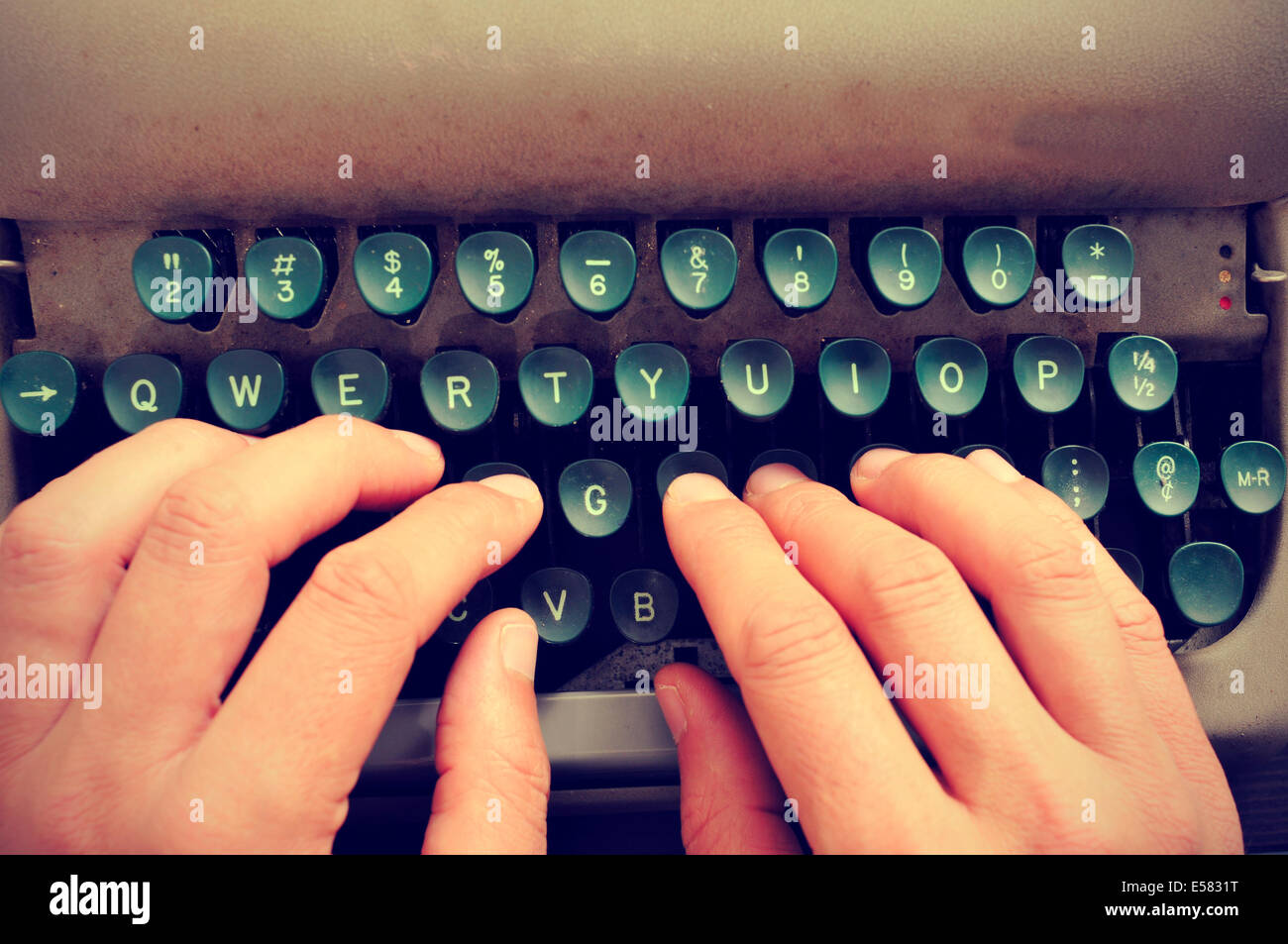 closeup of the hands of a man typing on an old typewriter Stock Photo