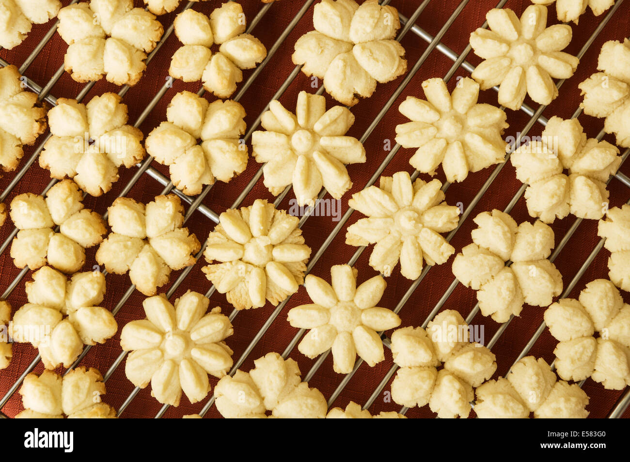 home made flower shaped press cookies cooling on a baking rack Stock Photo