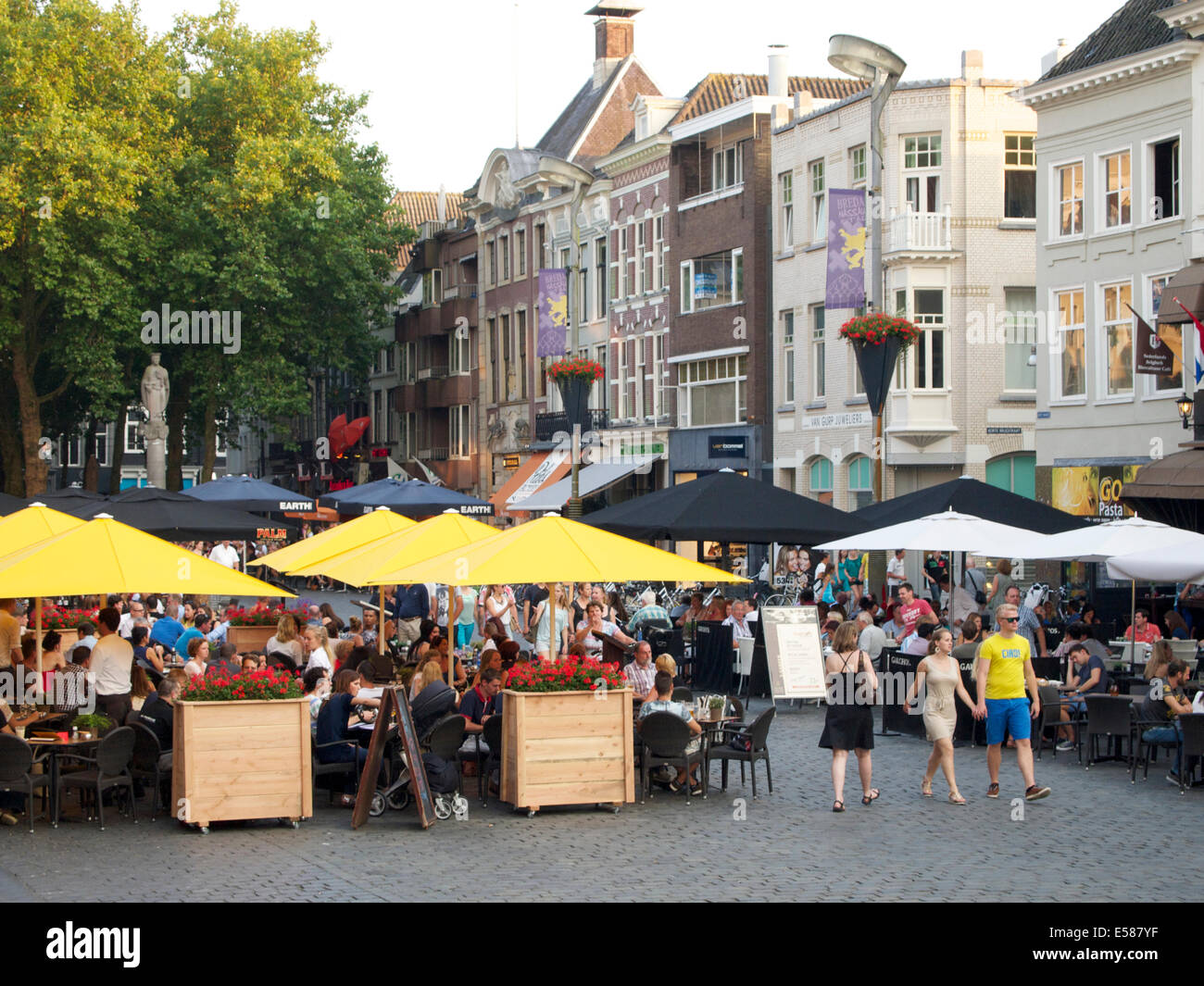 Summer evening in Breda, the Netherlands with many people on the Grote Markt square eating outside and having a drink. Stock Photo