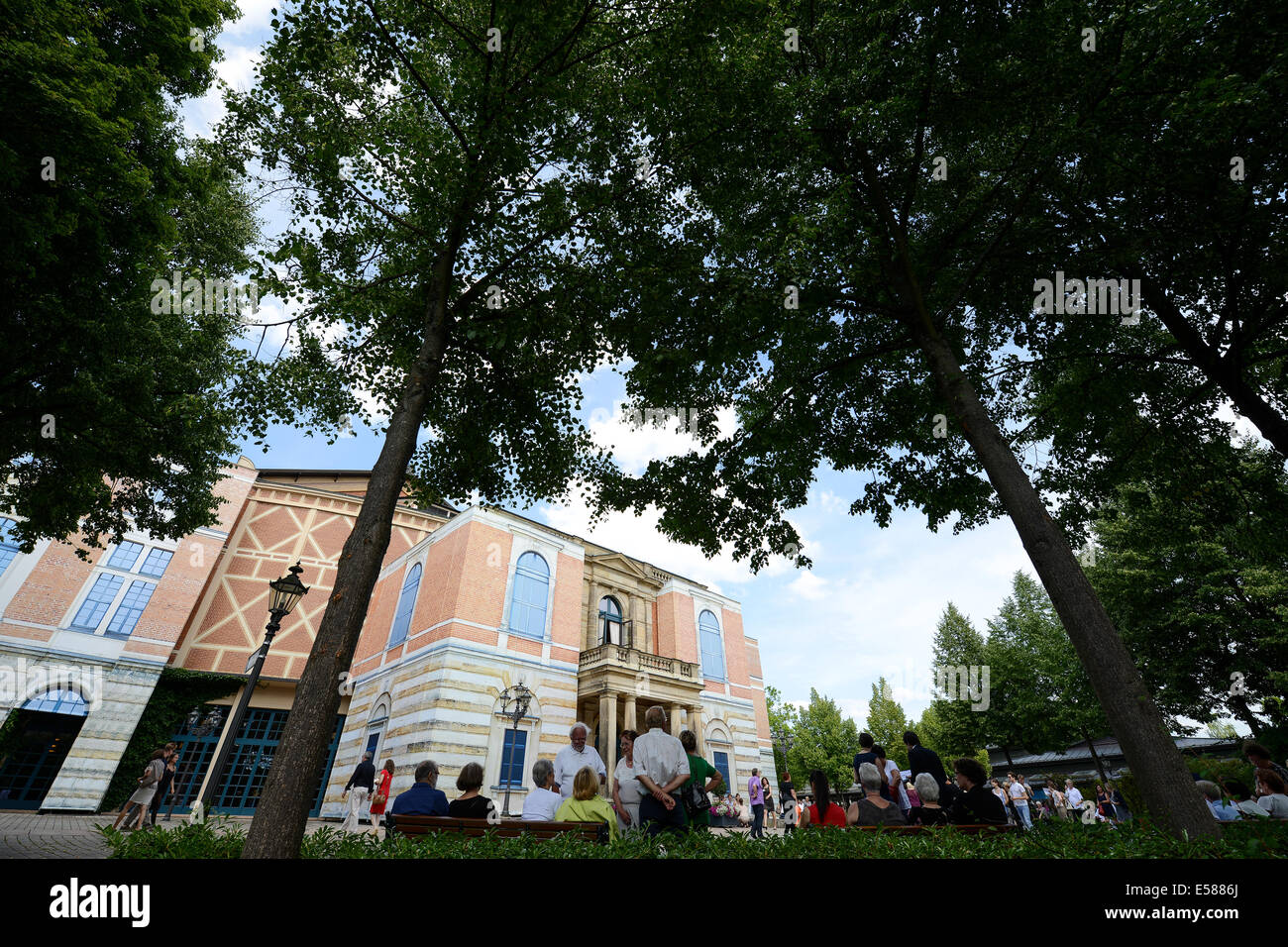 Bayreuth, Germany. 22nd July, 2014. Guests of the final rehearsal stand on Richard-Wagner square in front of the Bayreuth Festival Theatre in Bayreuth, Germany, 22 July 2014. Last year the festival presented a new production of 'Der Ring des Nibelungen' (The Ring of the Nibelung) which will run again this year. Photo: DAVID EBENER/dpa/Alamy Live News Stock Photo