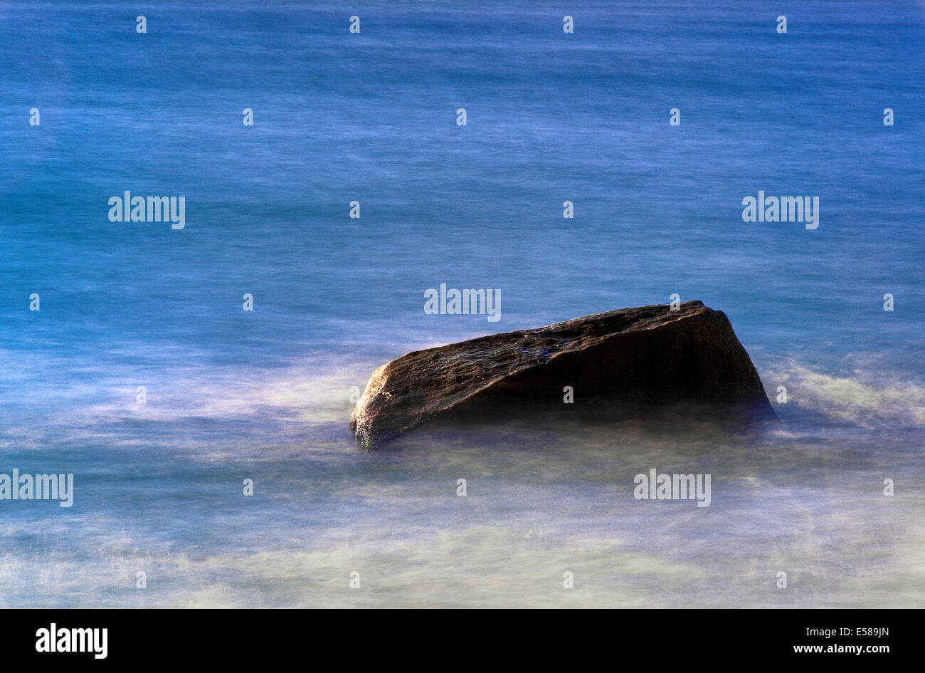 Rock with moving ocean water. Stock Photo