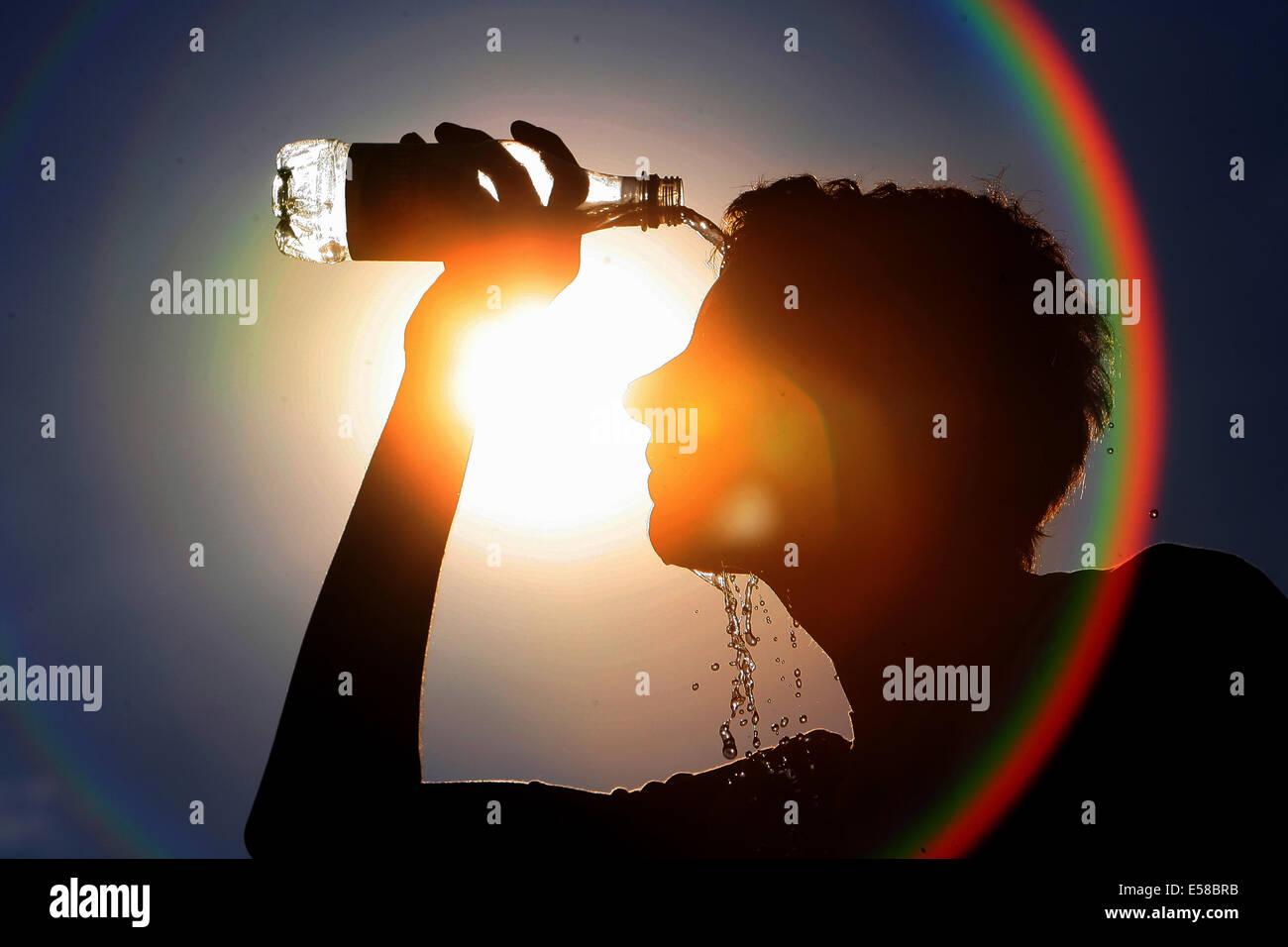 Pic Shows a man cooling off in the summer sun with a bottle of water Stock Photo