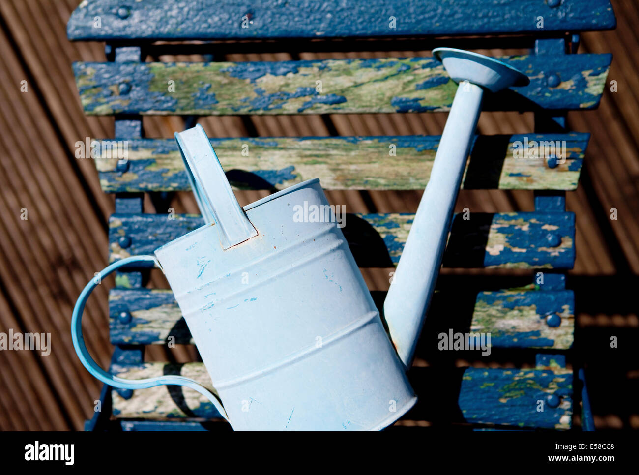 Watering can on blue chair on rooftop garden in Primrose Hill, London, UK Stock Photo