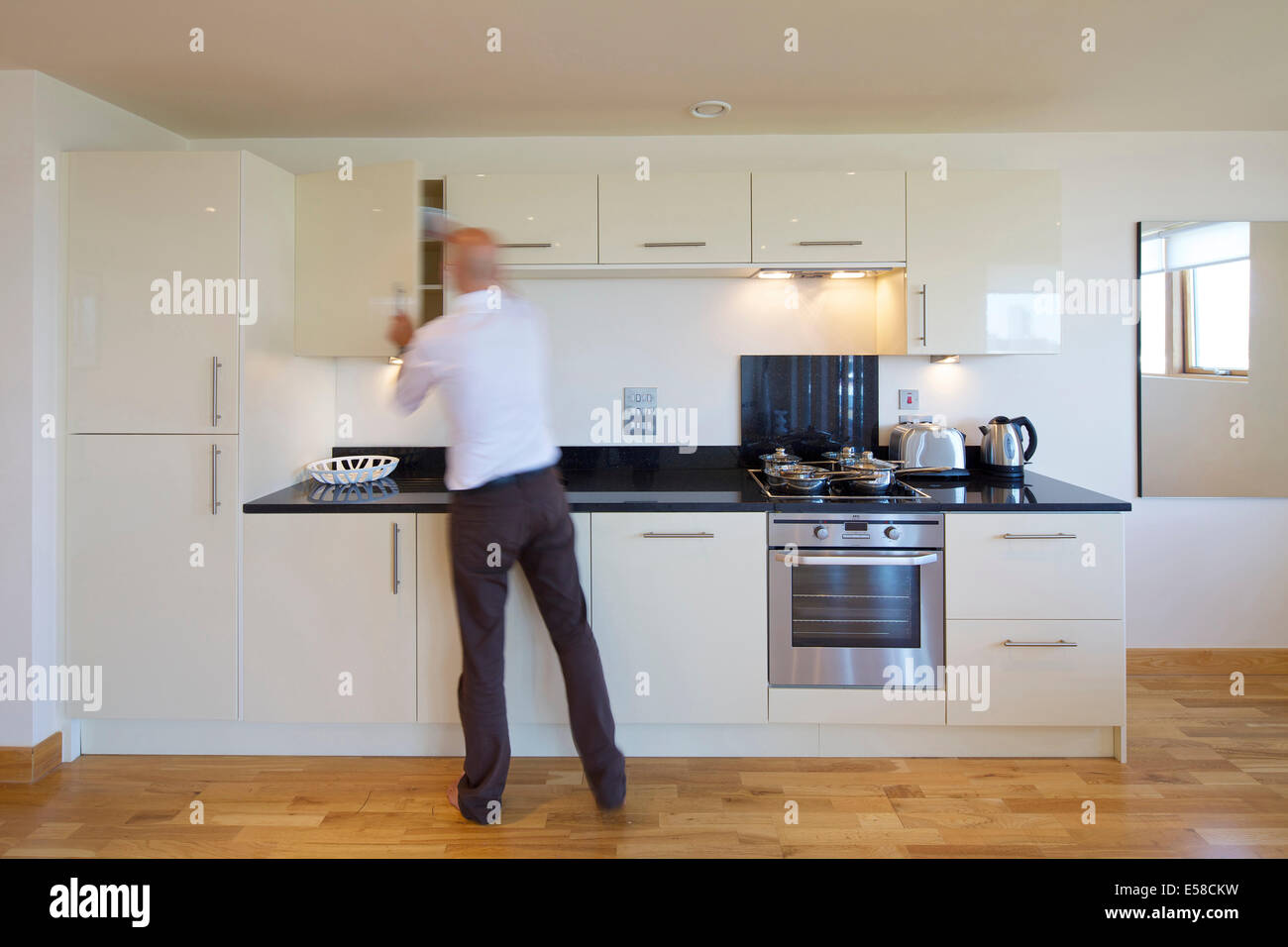 Man in kitchen at 419 Wick Lane London. New apartments built by Development securities Plc opposite the new Olympic Stadium in Stock Photo