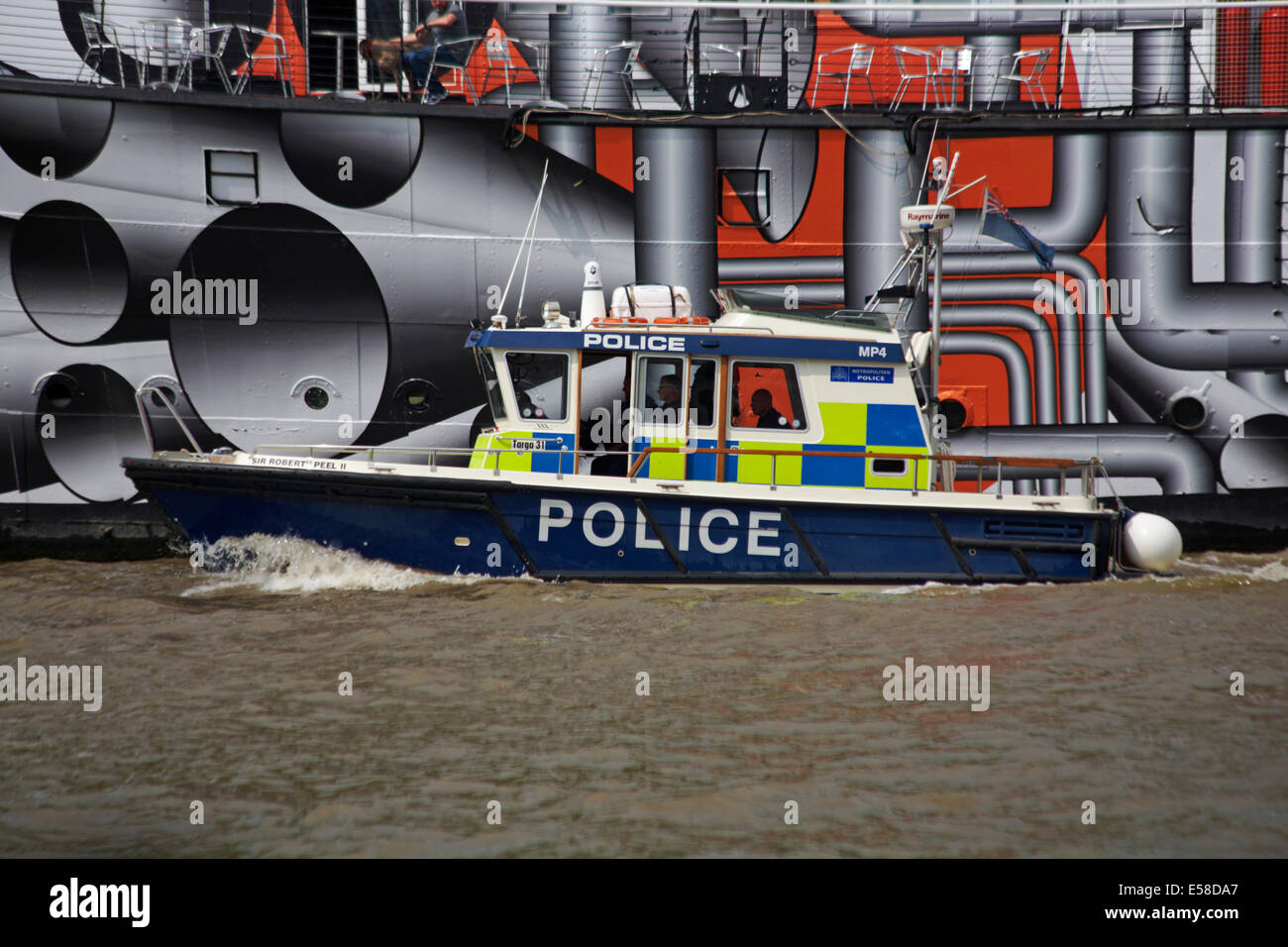 Metropolitan Police Boat Sir Robert Peel passing recently repainted HMS President on the Victoria Embankment, River Thames at London, UK in July Stock Photo