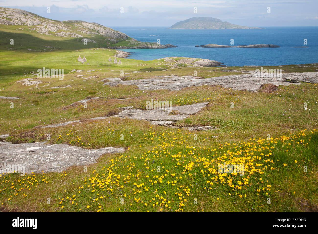 View over machair grassland to abandoned croft houses in the deserted village of Eorasdail, Vatersay Island, Barra, Scotland Stock Photo
