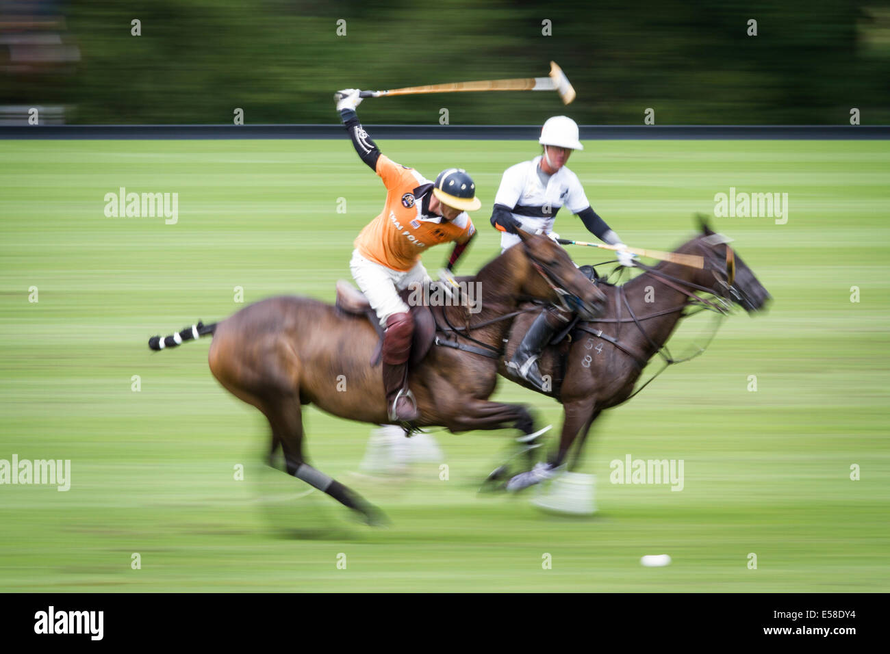 Polo players are blurred as they ride at speed Stock Photo Alamy