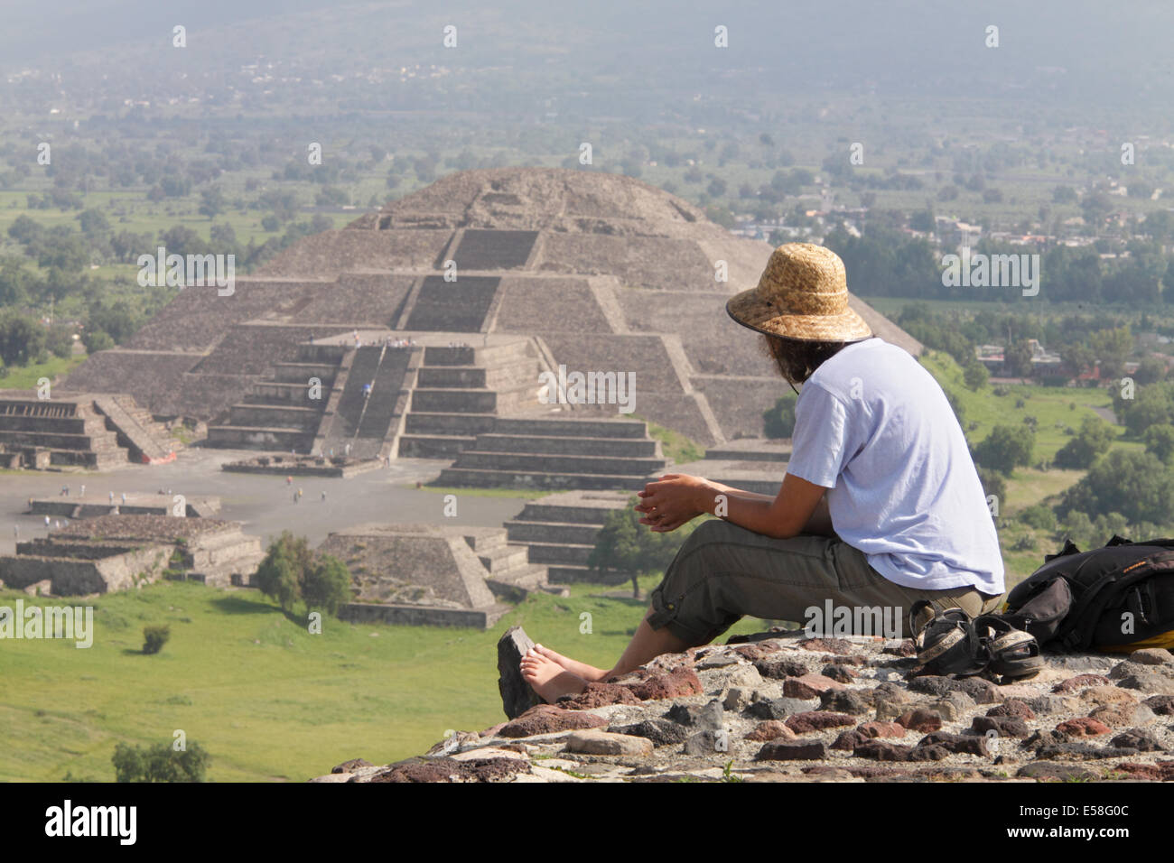 A tourist atop the Pyramid of the Sun gazes at the Pyramid of the Moon in the distance, Teotihuacan, Mexico. Stock Photo