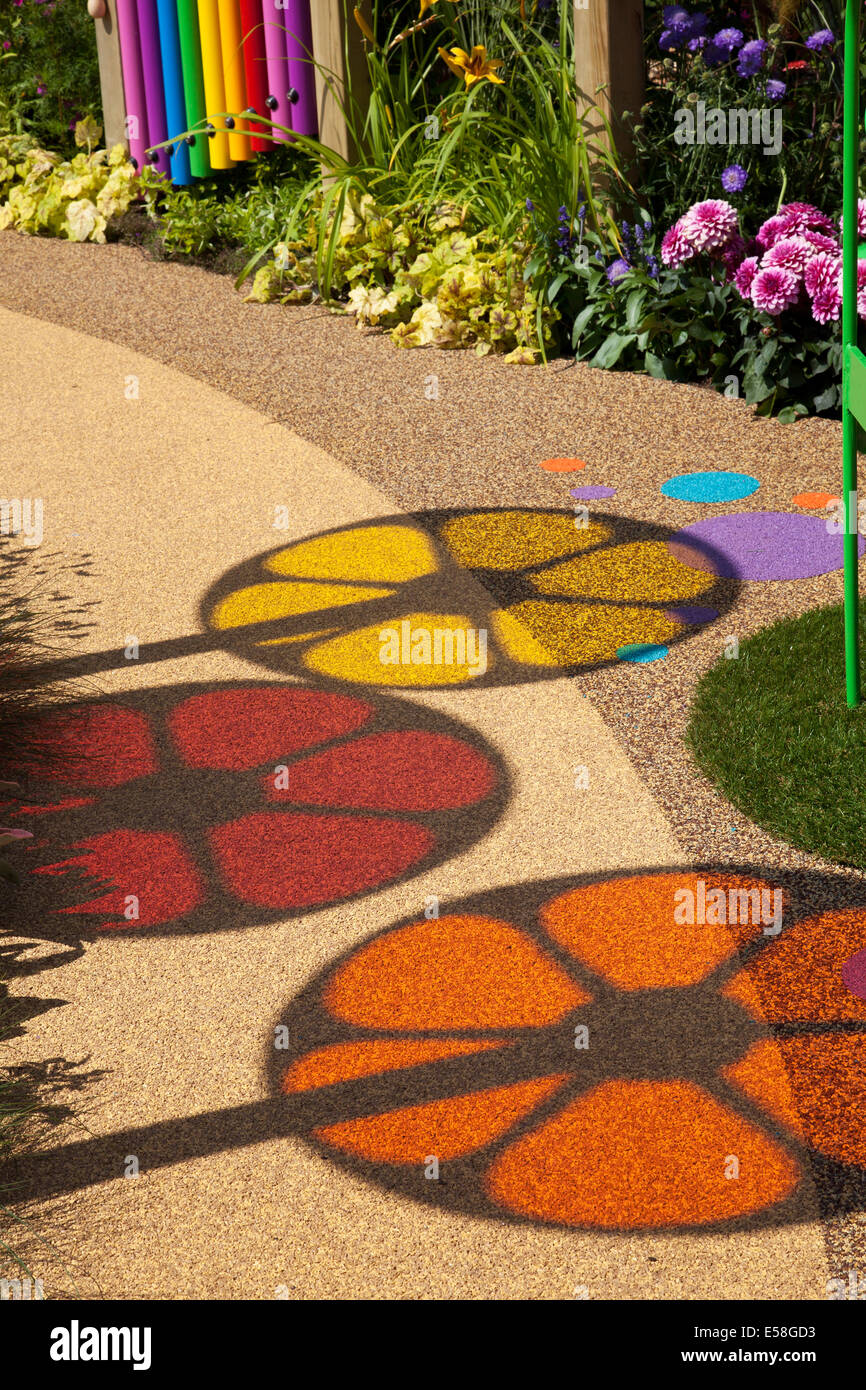 Tatton Park, Manchester, UK. 23rd July, 2014. Circular Images. and Coloured shadows, coloured circles, spinning wheels, shadows of colour, red, yellow orange patterns, round, vector, abstract, design, graphic, illustration, light, colours, bright, spectrum, element, art, colorful, icon, colour, color, palette, motion, pattern, blue, creative, fun spectrum on garden pathway at the RHS - Royal Horticultural Society carnival-themed event at Tatton Park. Stock Photo