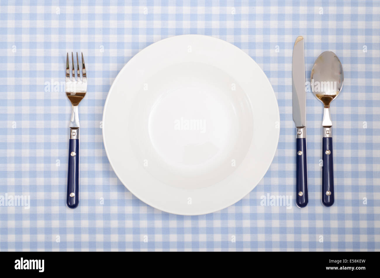 Cover with knife, fork, spoon , plate and checkered table cloth in a restaurant Stock Photo