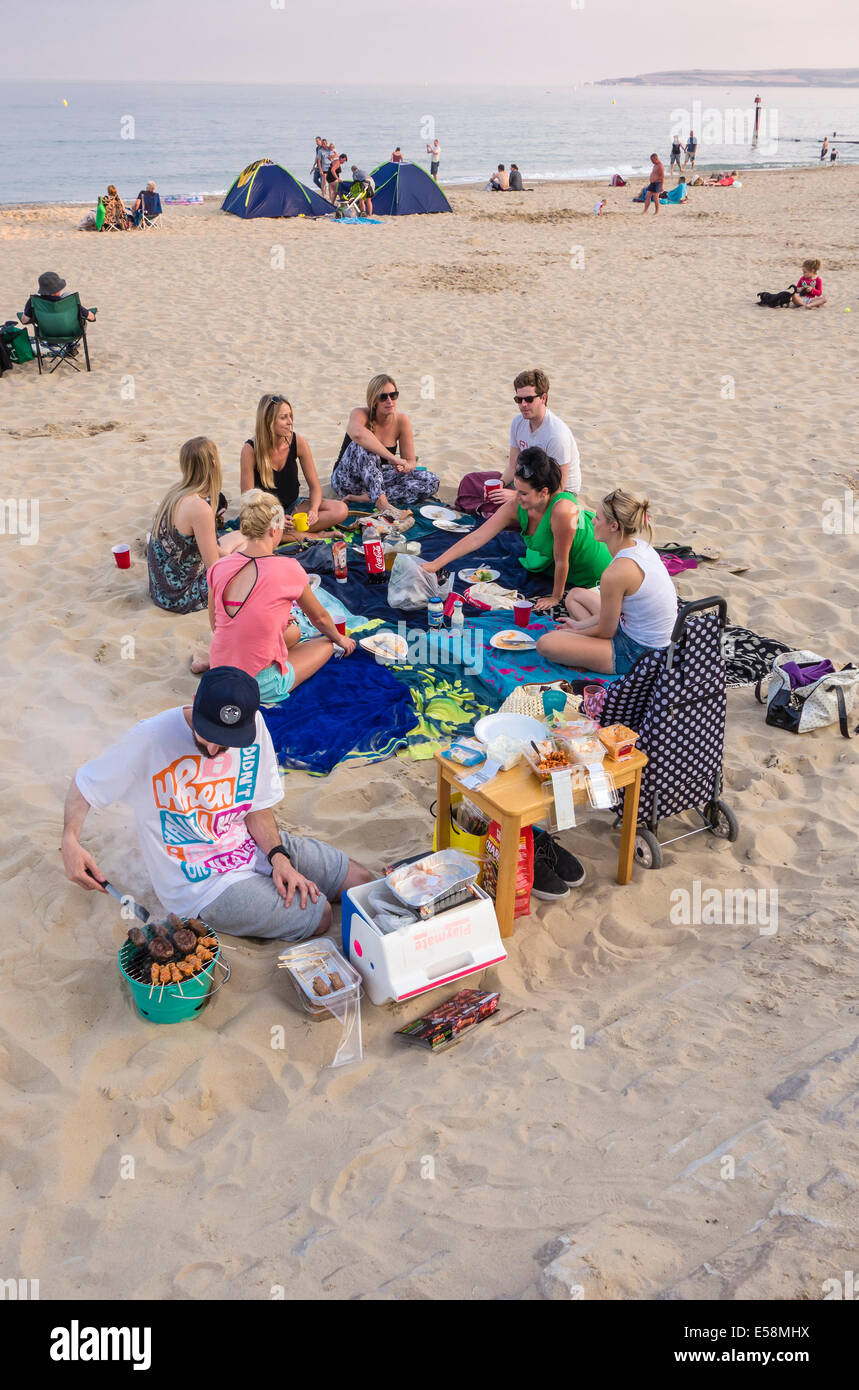 A barbecue on the Beach, on a warm evening, enjoyed by a group of young