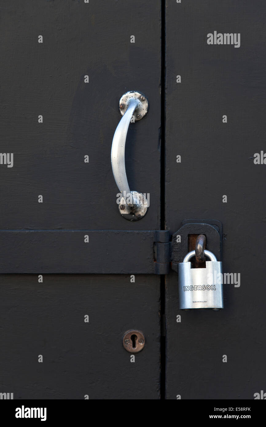 Closeup black of door with handle and padlock Stock Photo