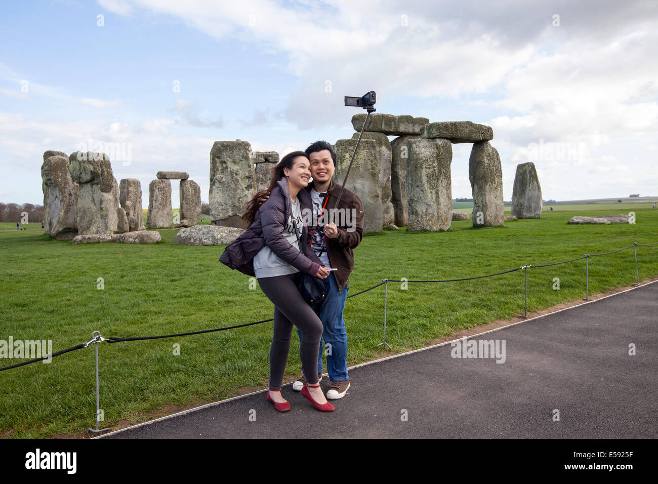 Tourists photograph themselves and the stones at the standing stone circle at Stonehenge, Wiltshire, UK Stock Photo