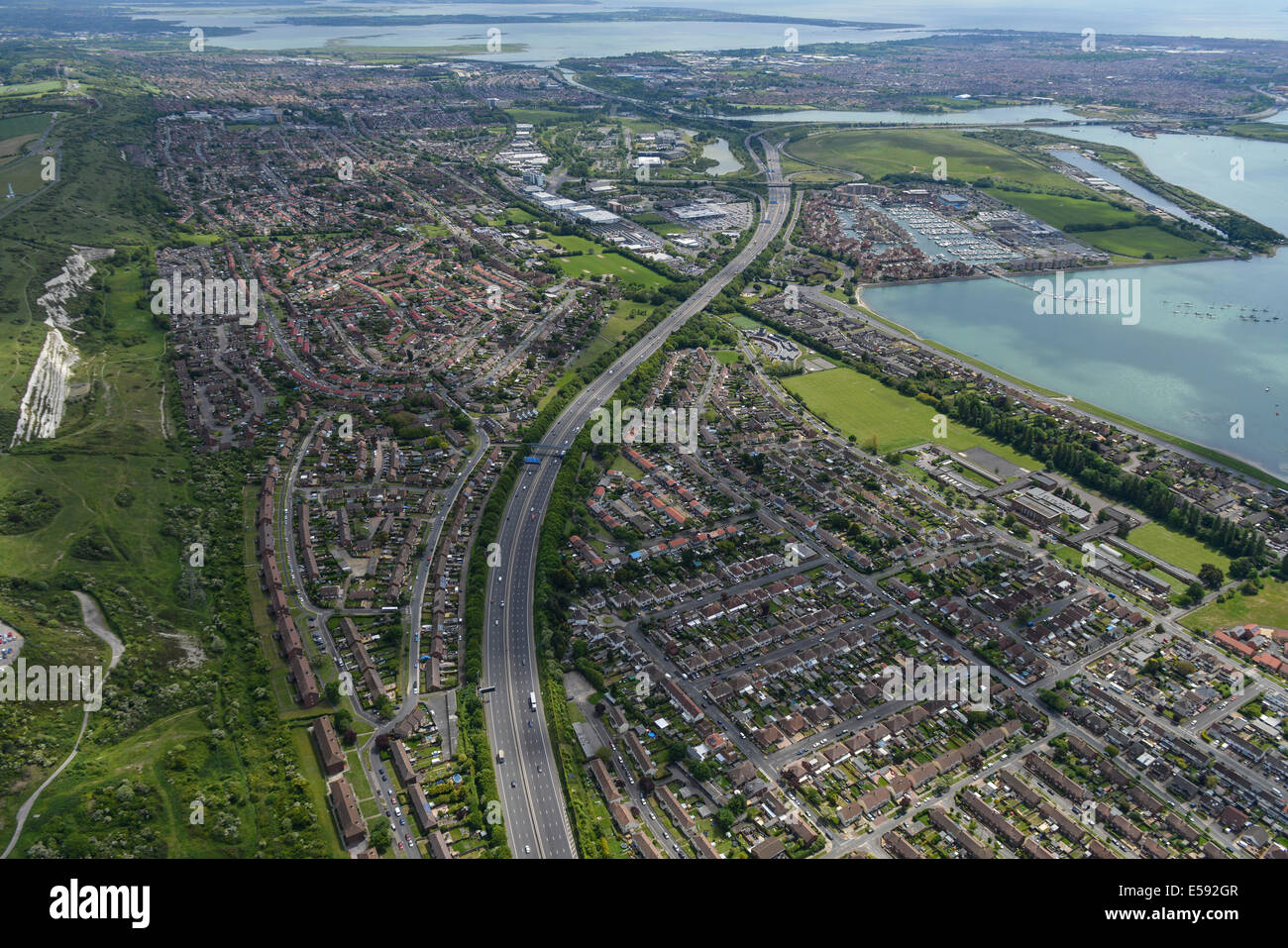An aerial view looking down the M27 with Paulsgrove and Portchester in the foreground and Portsmouth in the distance. Stock Photo