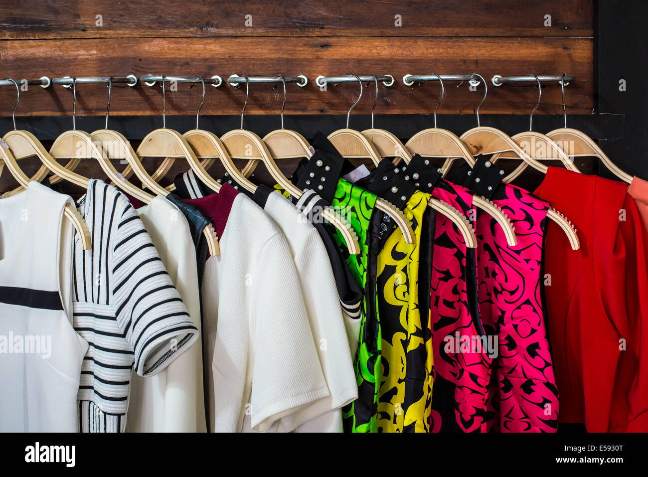 Many blouses on hangers in the dressing room. Stock Photo