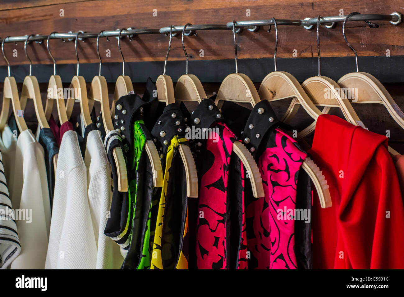 Many blouses on hangers in the dressing room. Stock Photo