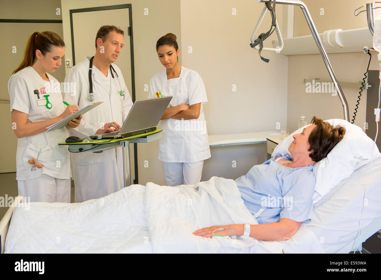 Medical team attending female patient on hospital bed Stock Photo