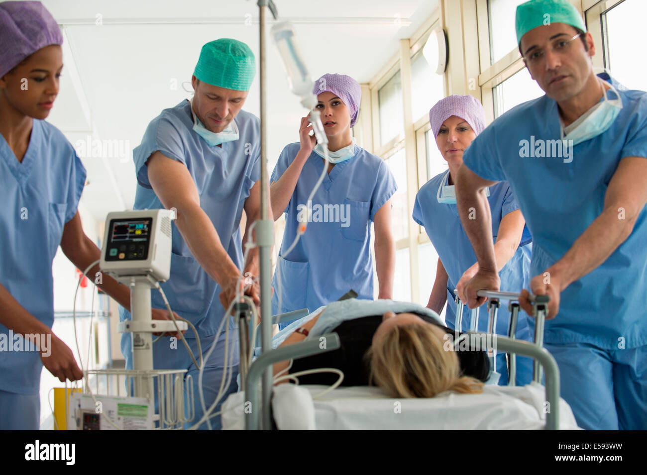 Medical professionals pushing patient on gurney in a hospital Stock