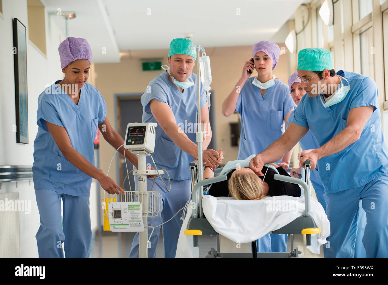Medical professionals pushing patient on gurney in a hospital Stock