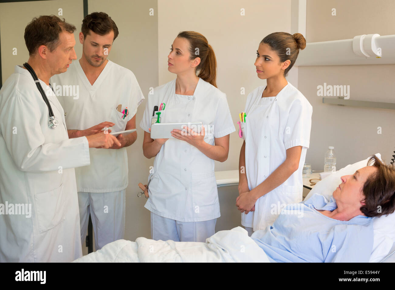 Medical team attending female patient on hospital bed Stock Photo Alamy