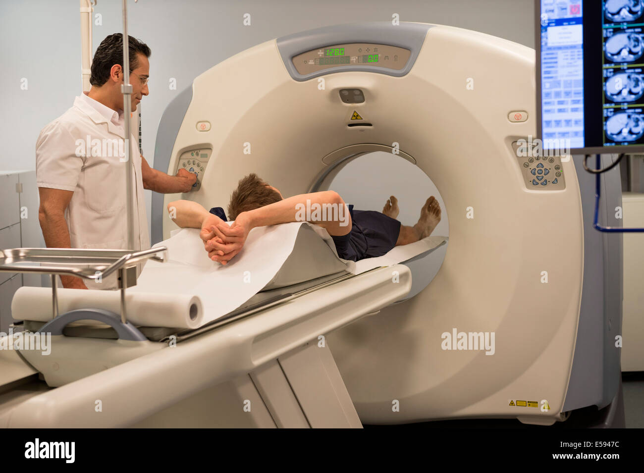 Male doctor preparing patient for MRI scan in hospital Stock Photo