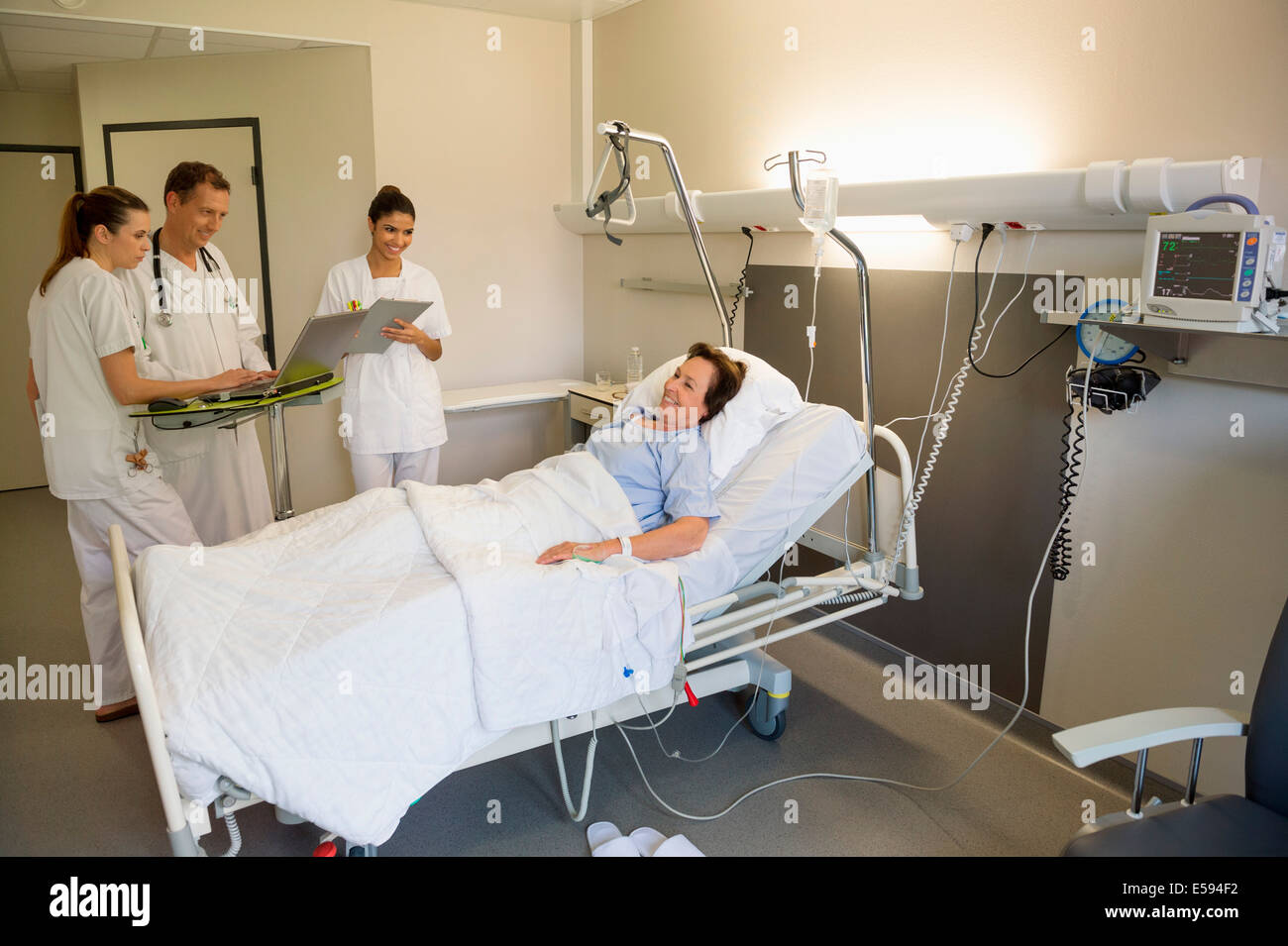 Medical team attending female patient on hospital bed Stock Photo Alamy