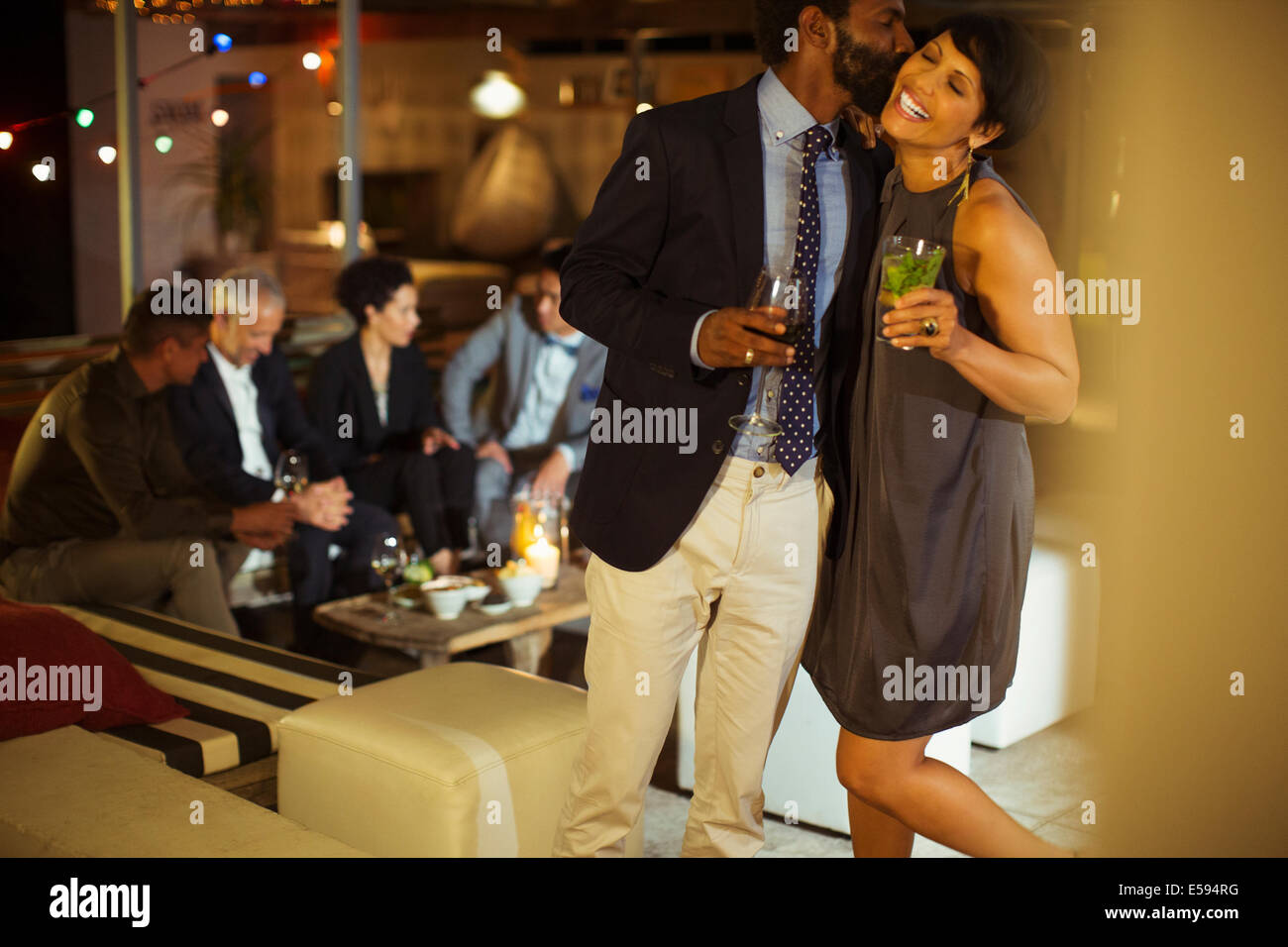 Couple kissing at party Stock Photo