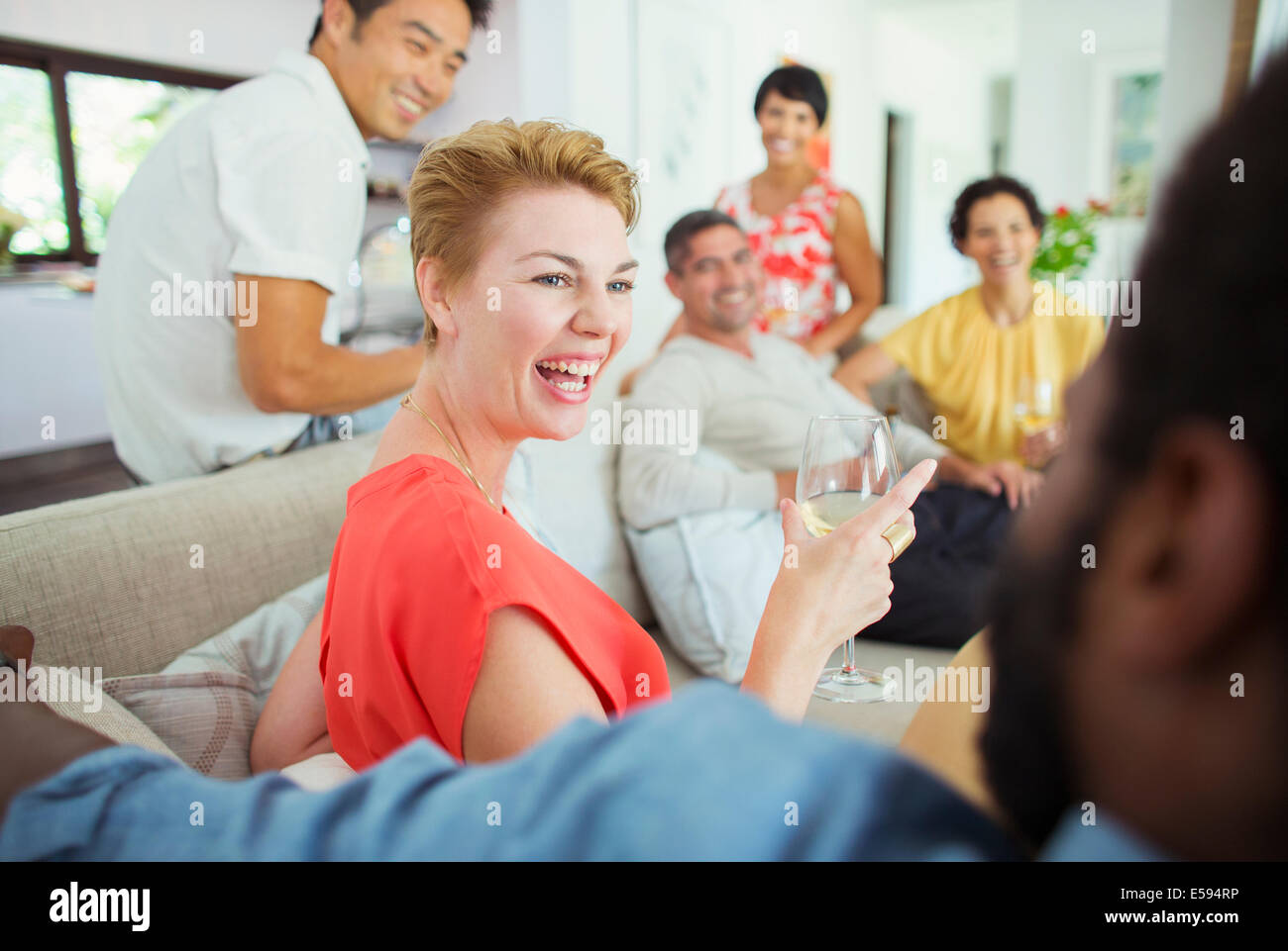 Friends laughing together at party Stock Photo