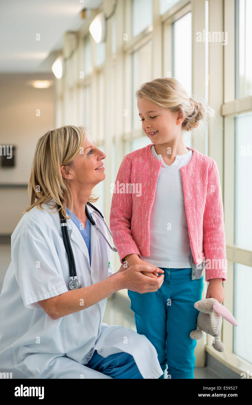 Female doctor talking to a girl in the corridor of a hospital Stock Photo