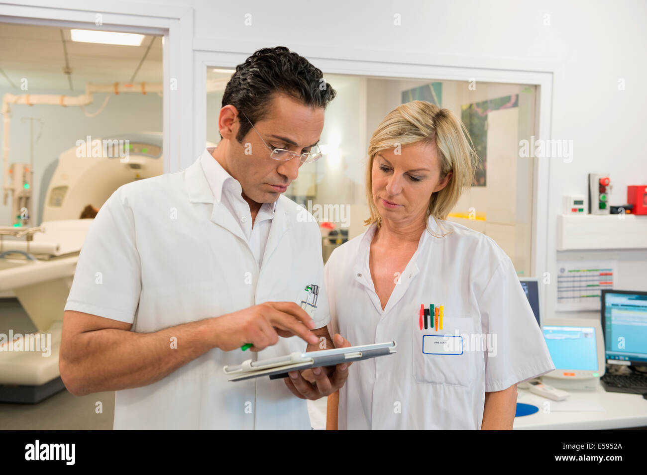 Doctors examining MRI scan report in medical scan room Stock Photo