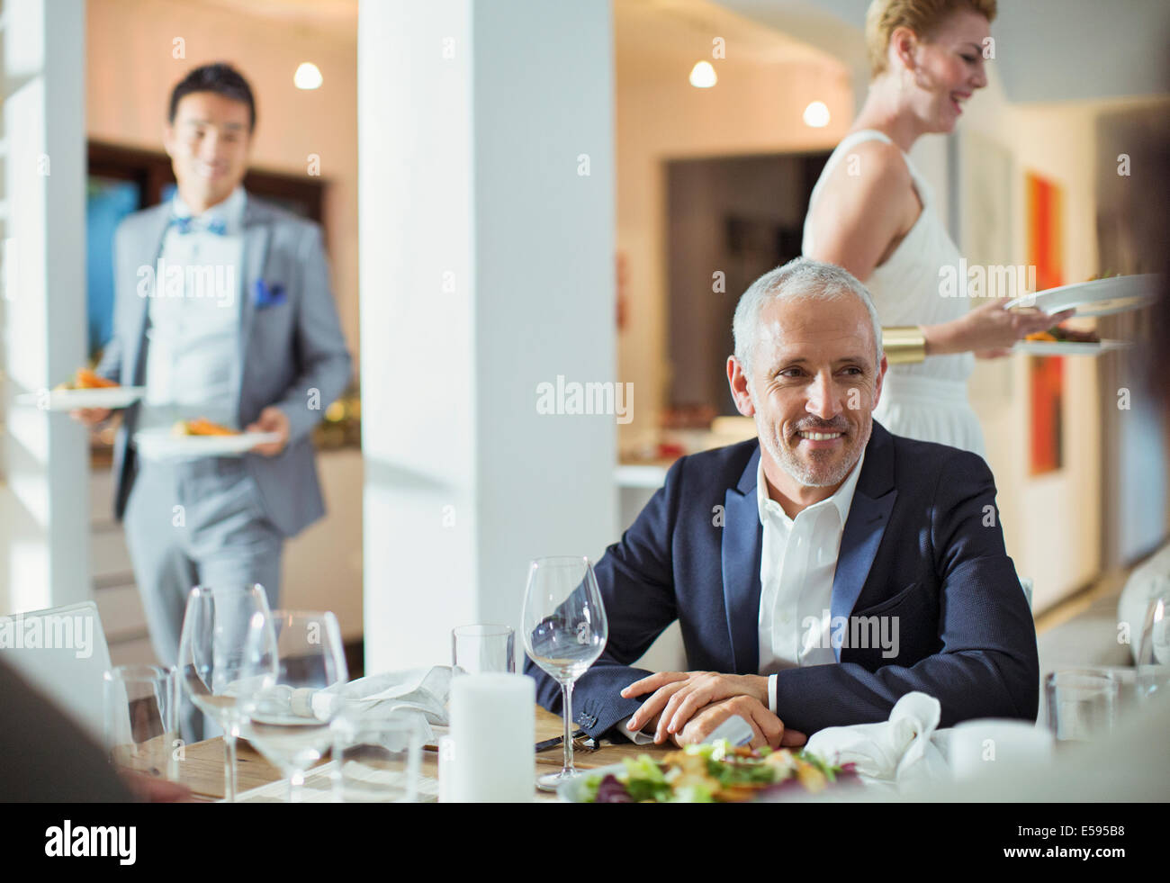 Man sitting at table at dinner party Stock Photo