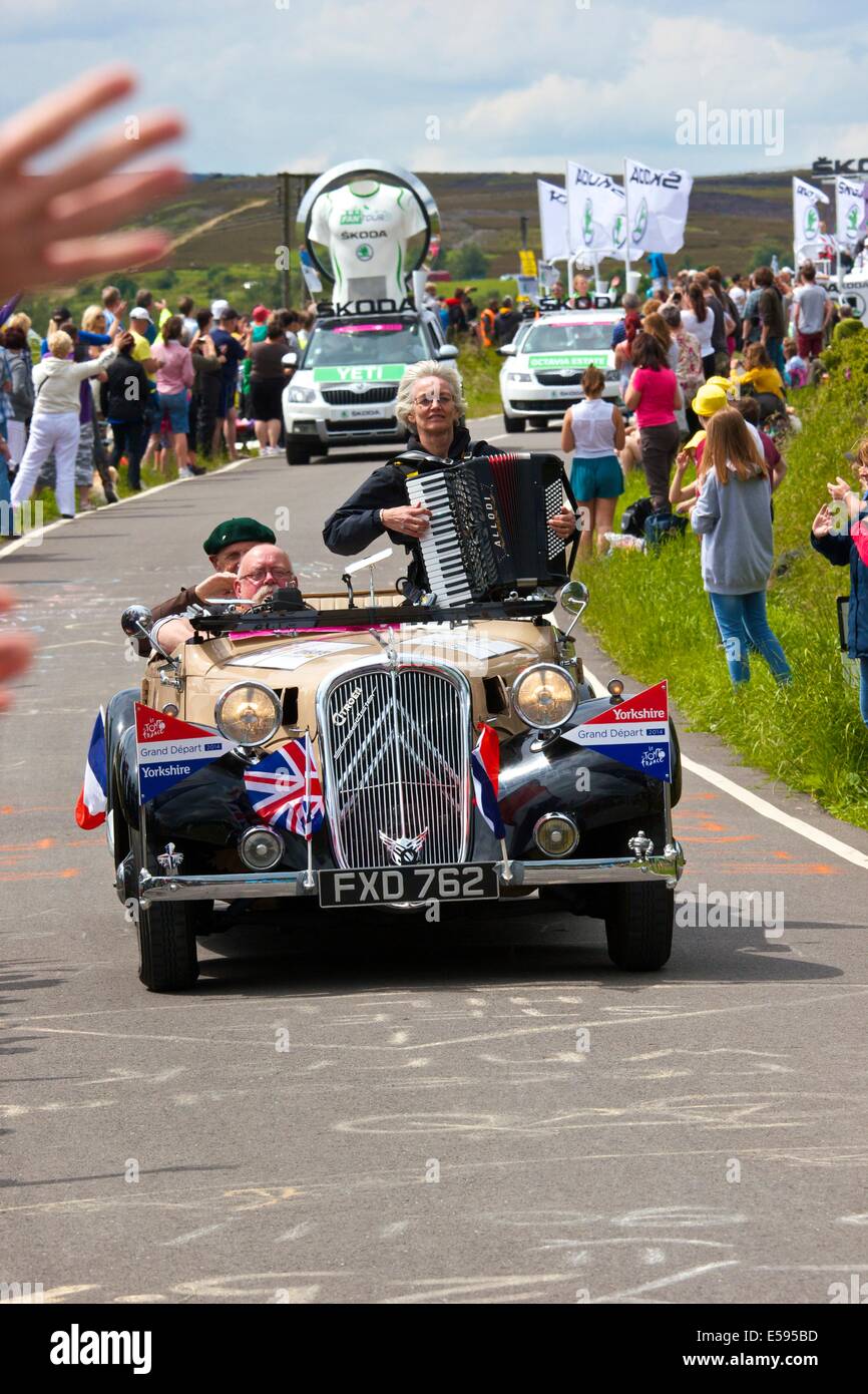 Woman playing an accordion in a classic convertible Citroen car part of the 2014 Tour de France caravan south Yorkshire England Stock Photo