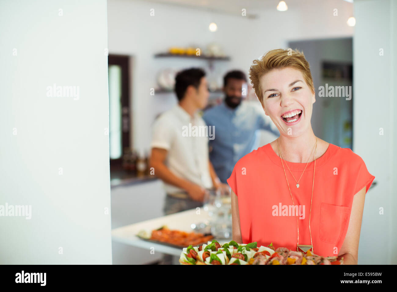 Woman carrying tray of food at party Stock Photo