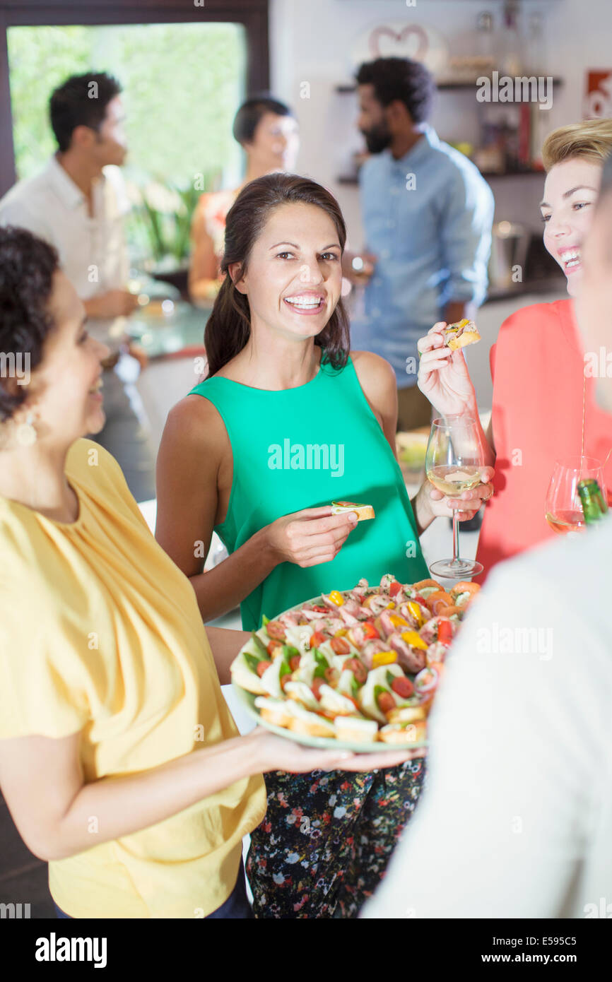 Woman serving friends at party Stock Photo