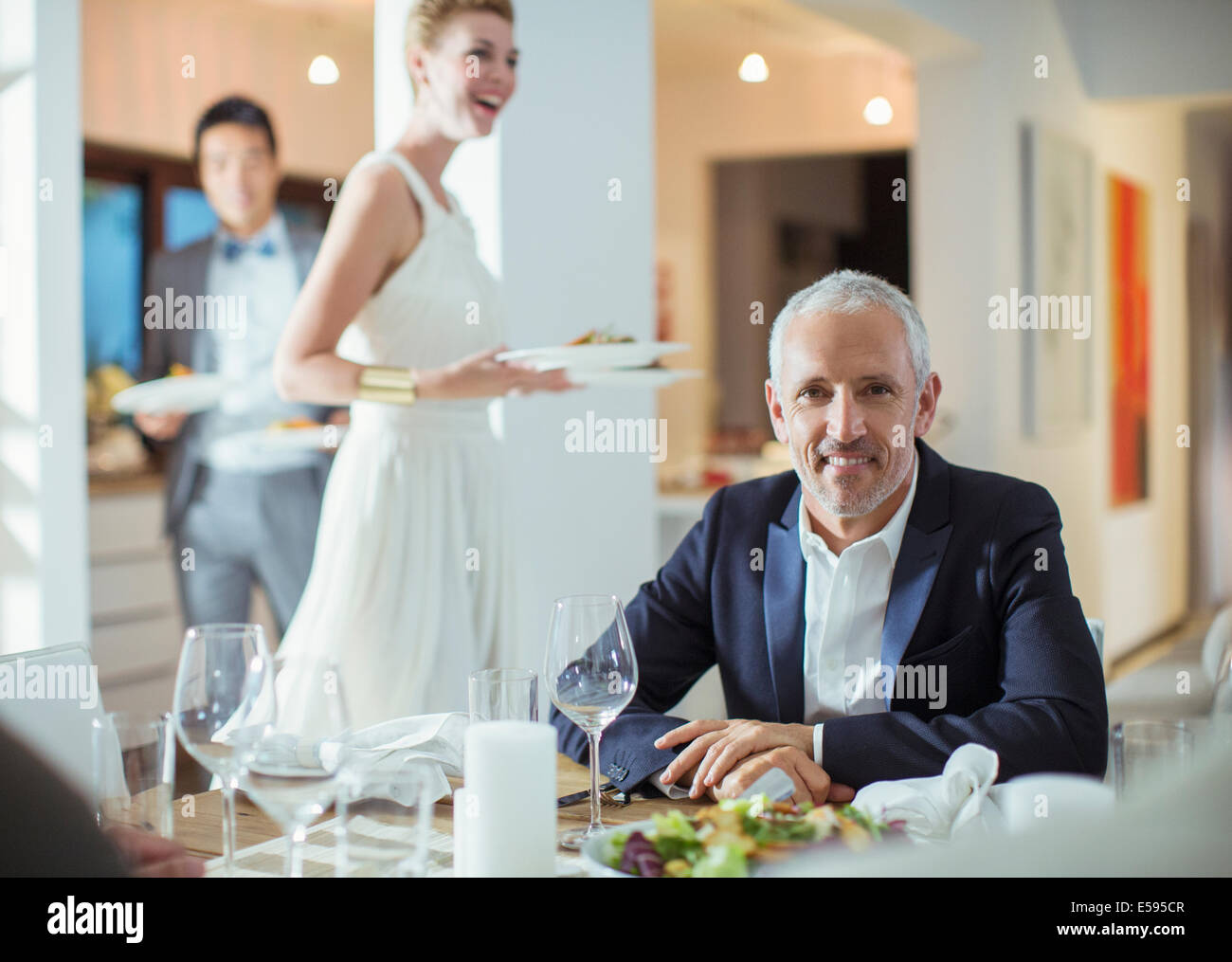 Man smiling at table at dinner party Stock Photo