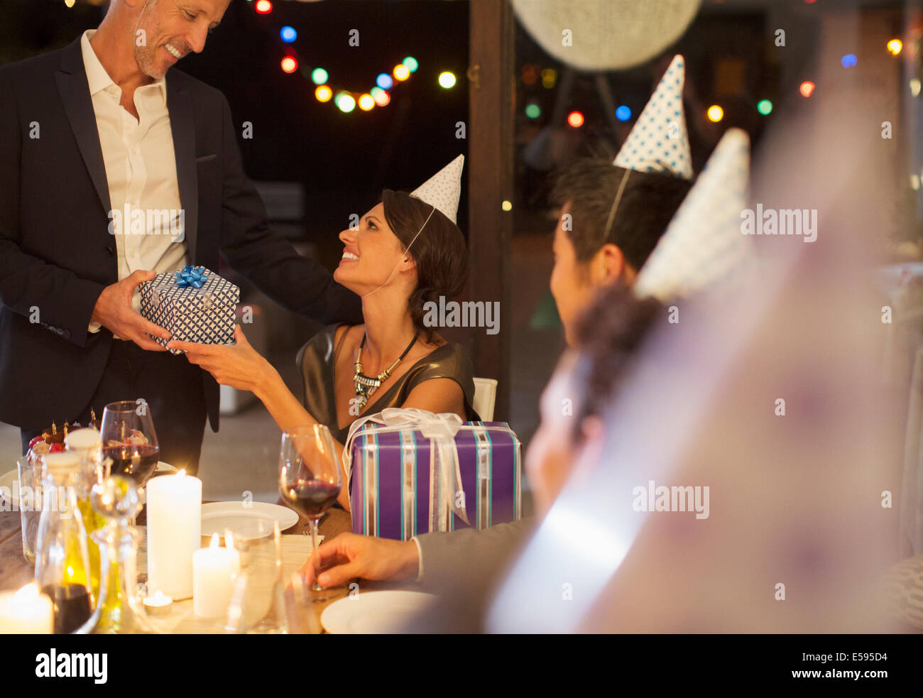Man giving present at birthday party Stock Photo
