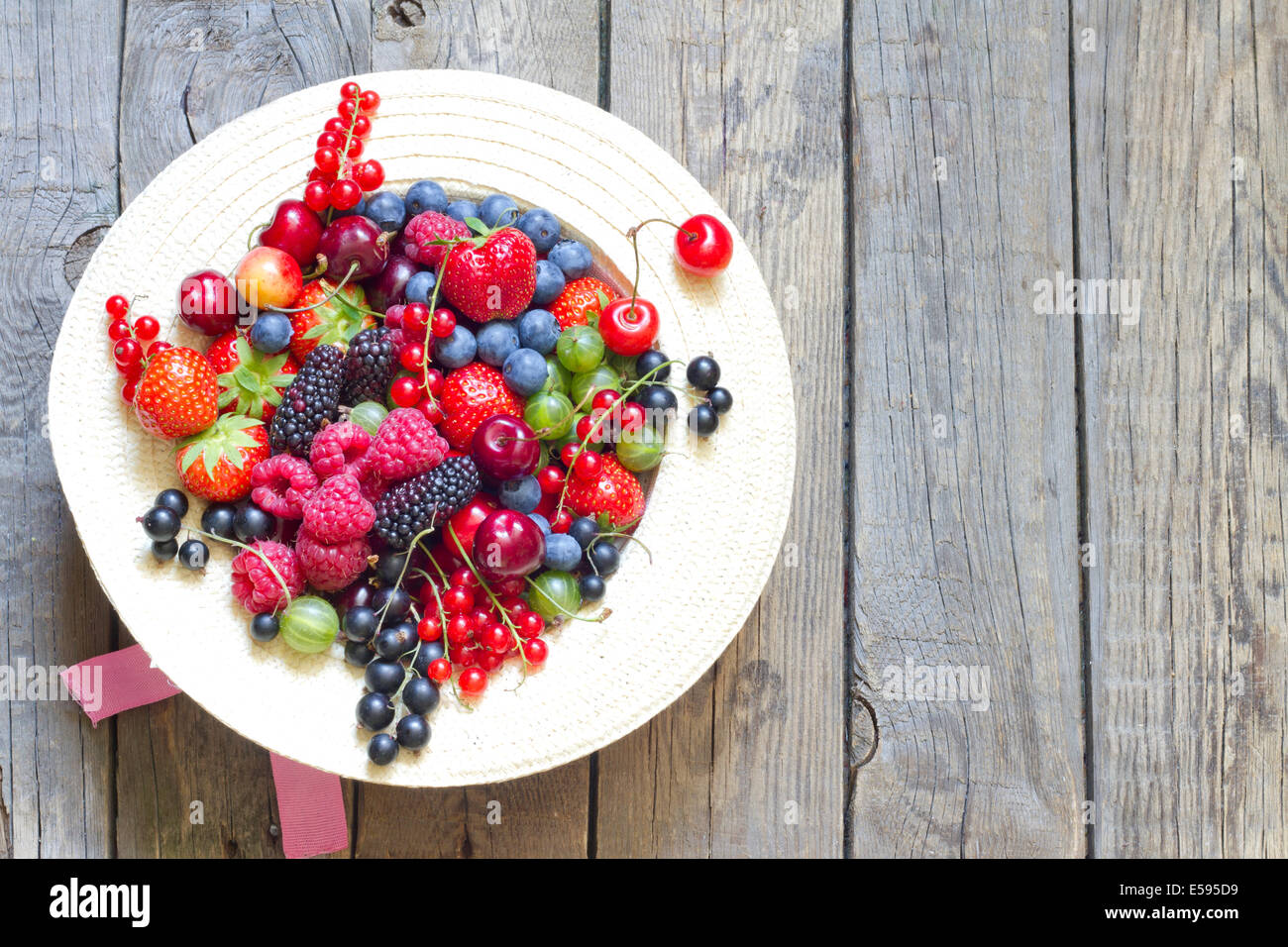 Summer wild berry fruits on vintage board still life concept Stock Photo