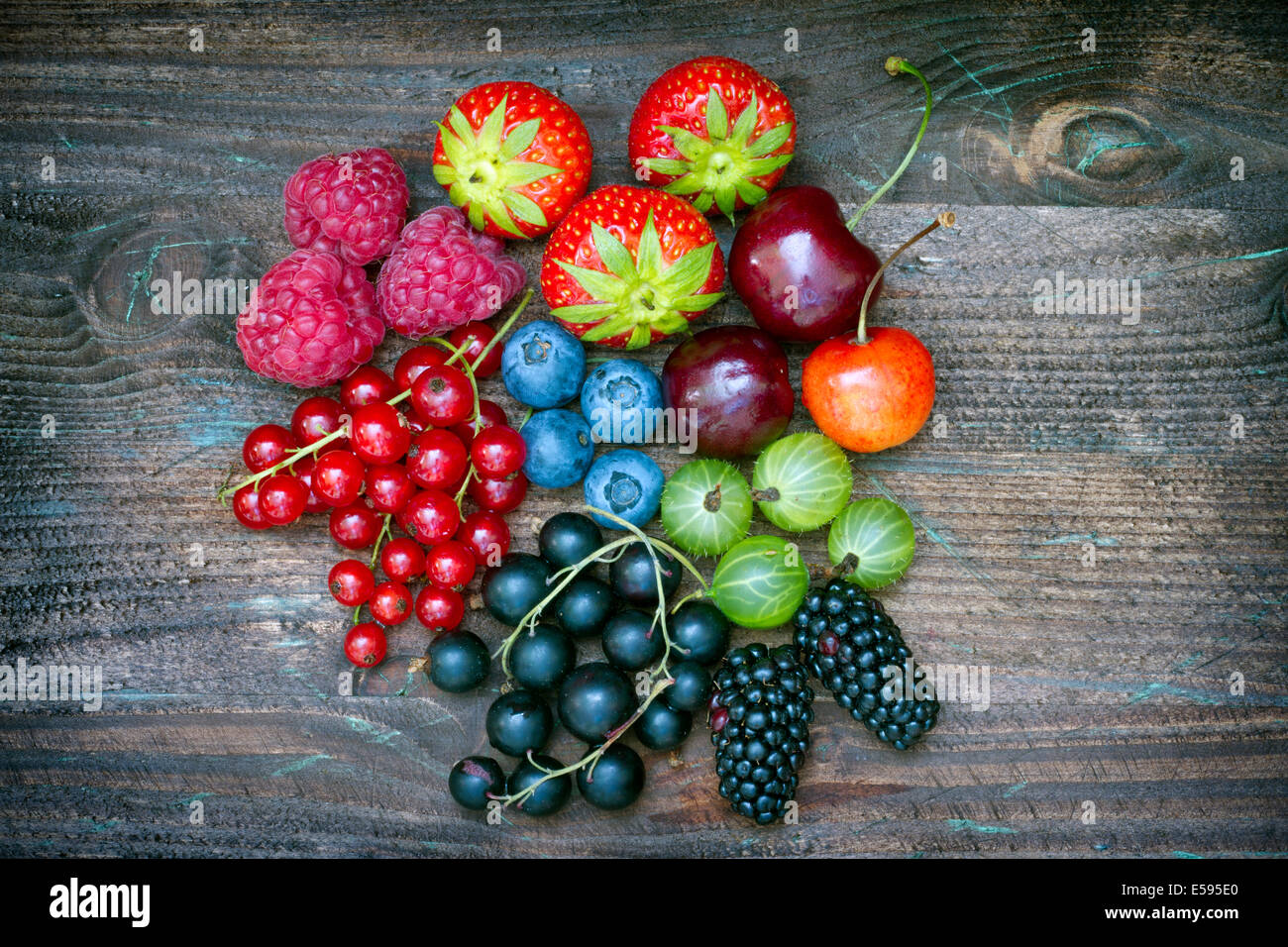 Summer wild berry fruits on vintage board still life concept Stock Photo