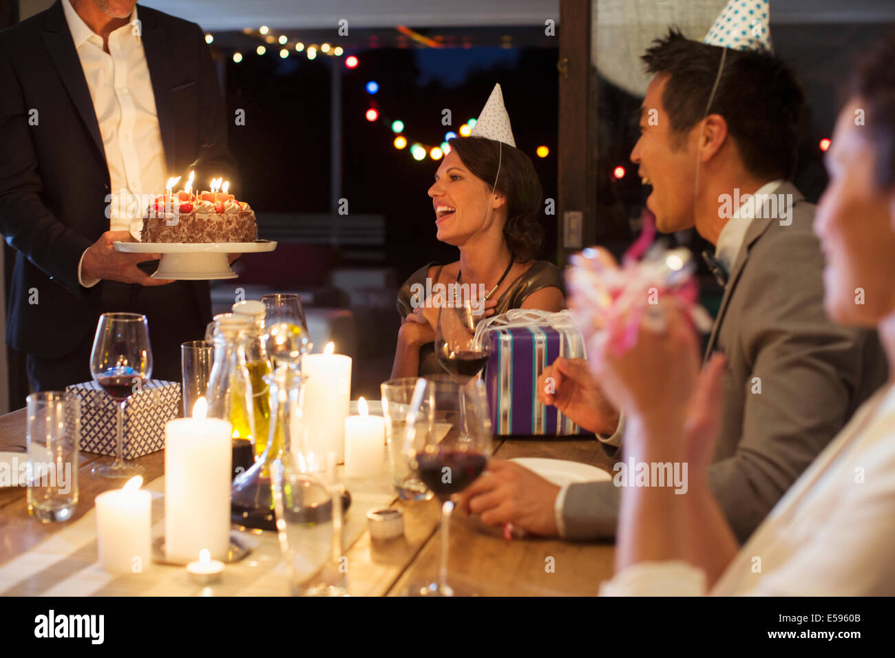 Man serving birthday cake at party Stock Photo
