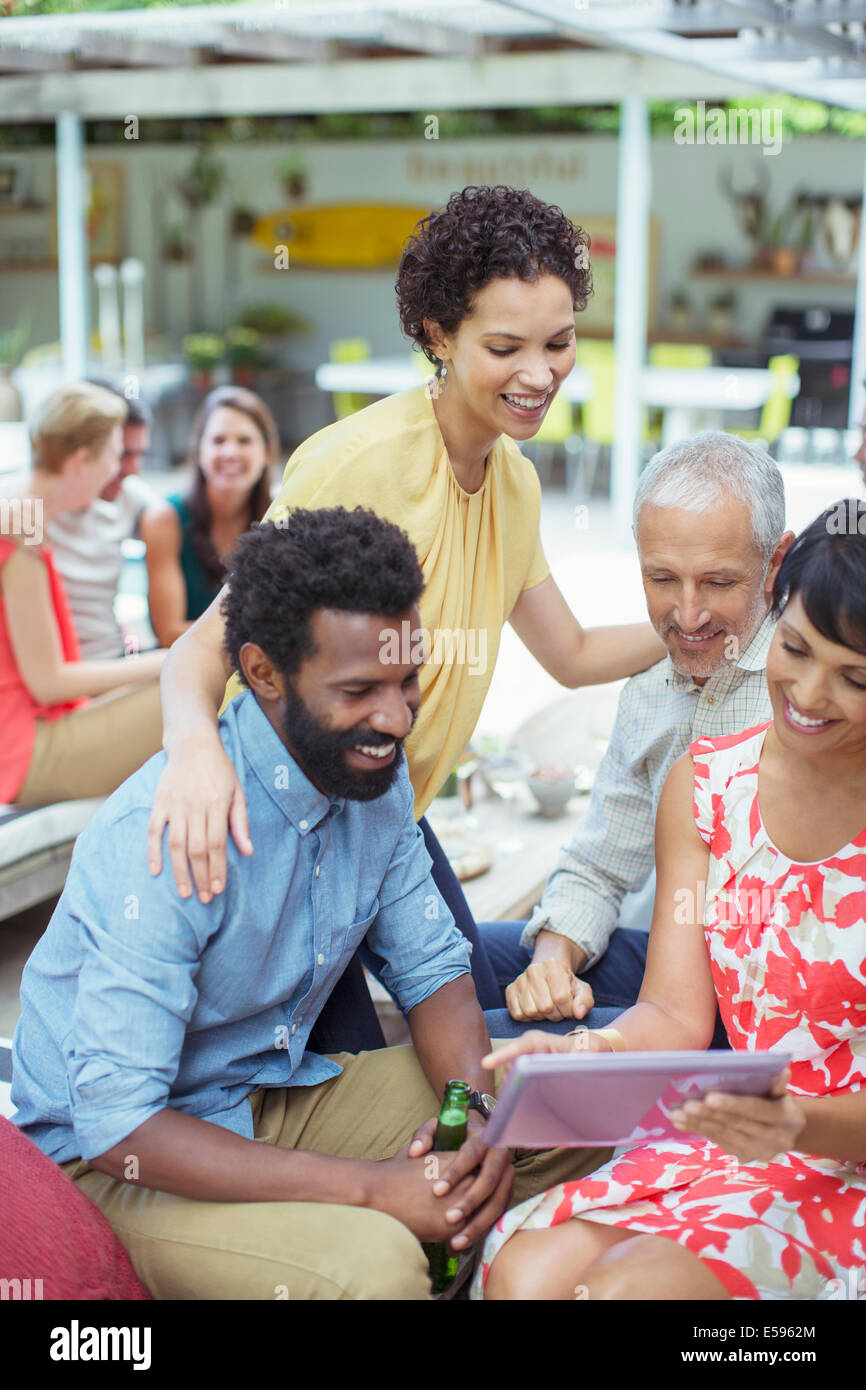 Friends using digital tablet at party Stock Photo