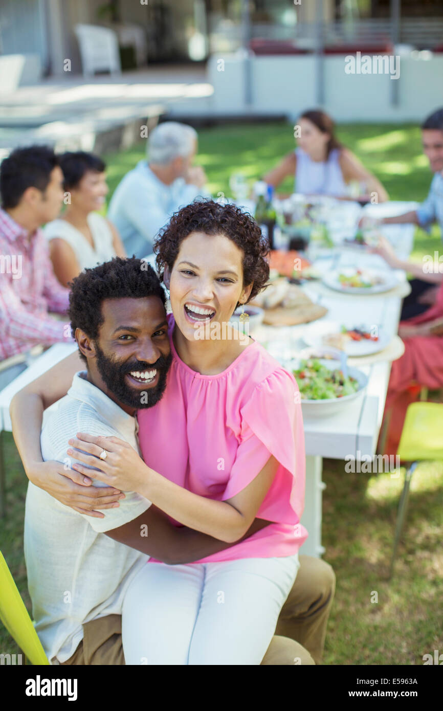Couple hugging at table outdoors Stock Photo