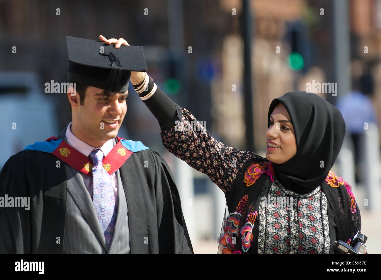 Manchester,  UK.  24th July, 2014. Mohammed Adel has his mortar board adjusted before entering The Bridgewater Hall to receive his B.Sc. in Business Information Technology, which he gained with First Class Honours. Graduation (Manchester Metropolitan University) Manchester, UK Credit:  John Fryer/Alamy Live News Stock Photo