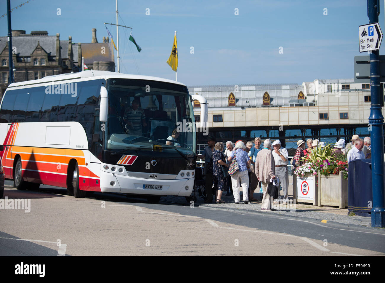 Aberystwyth, Wales, UK. 24th July, 2014.  A group of senior people emerge from their tour coach on a hot sunny morning at  Aberystwyth on the west Wales coast UK.  The heatwave is expected to last at least  another day, with project temperatures almost reaching 30c in some inland places, before cooler weather returns at the weekend  photo Credit:  keith morris/Alamy Live News Stock Photo