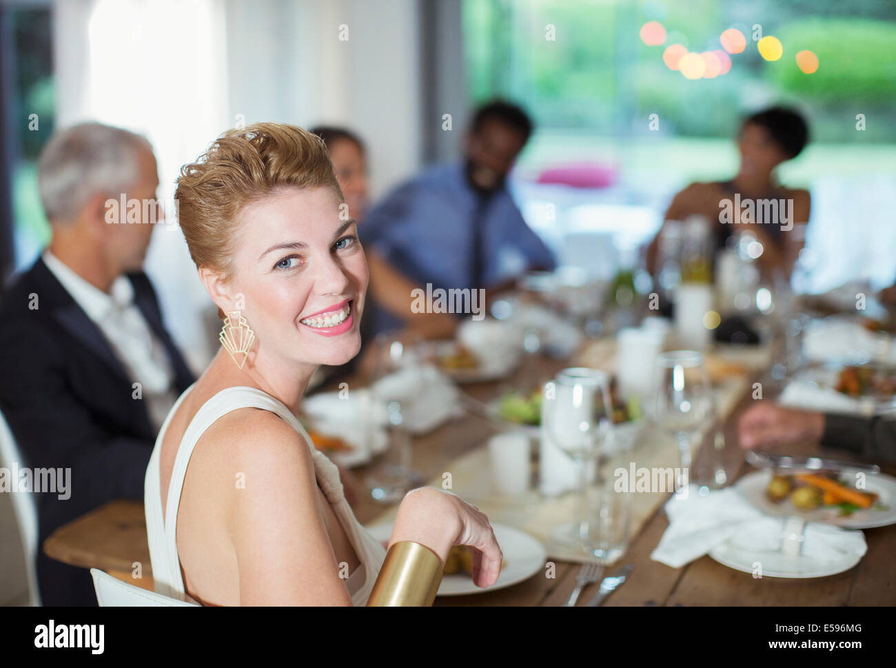 Woman smiling at dinner party Stock Photo