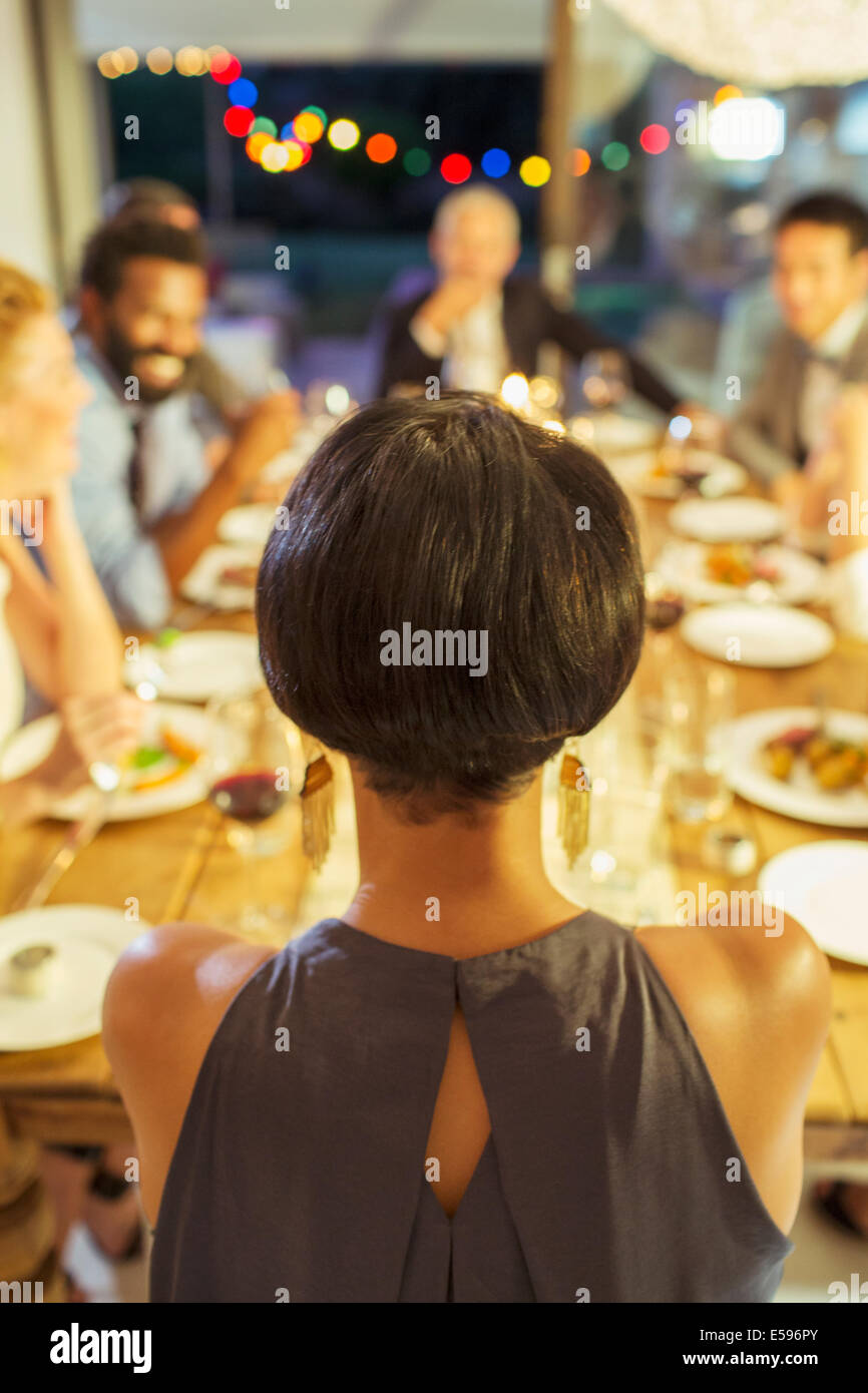 Woman sitting at dinner party Stock Photo