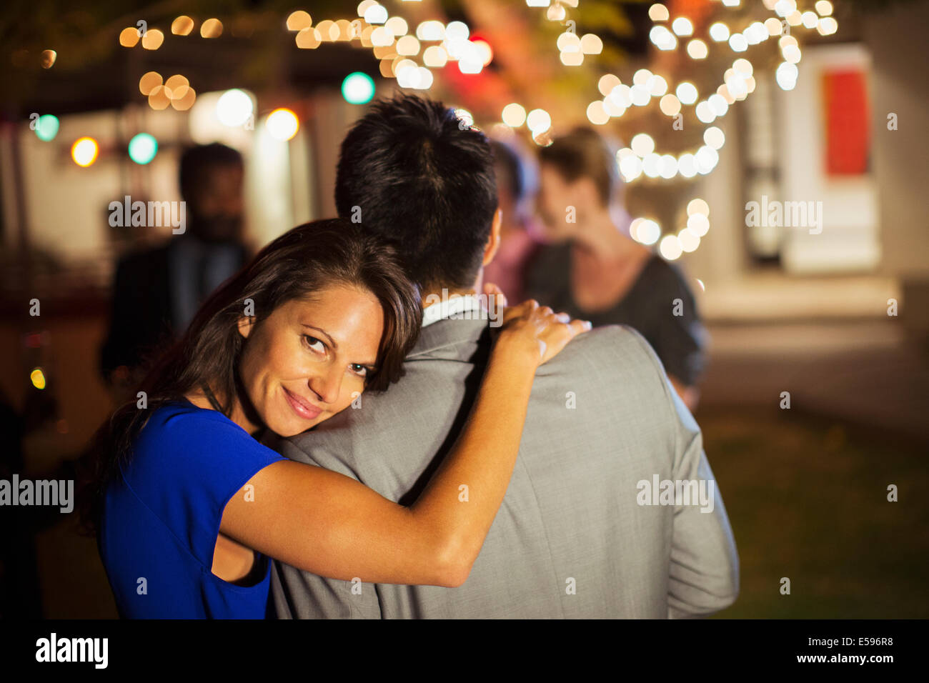 Couple hugging at party Stock Photo