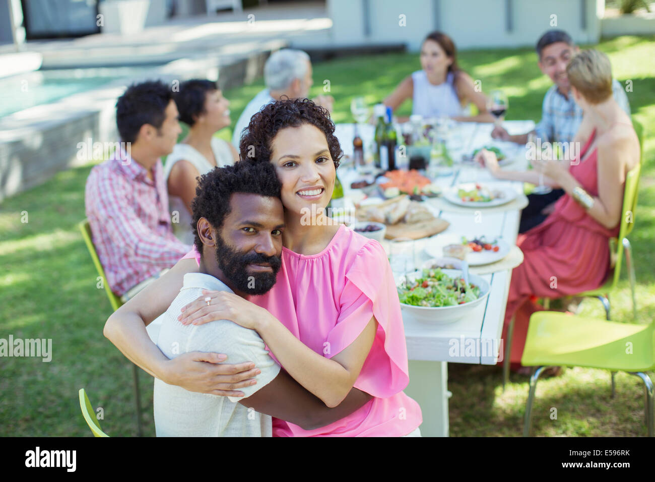 Couple hugging at table outdoors Stock Photo