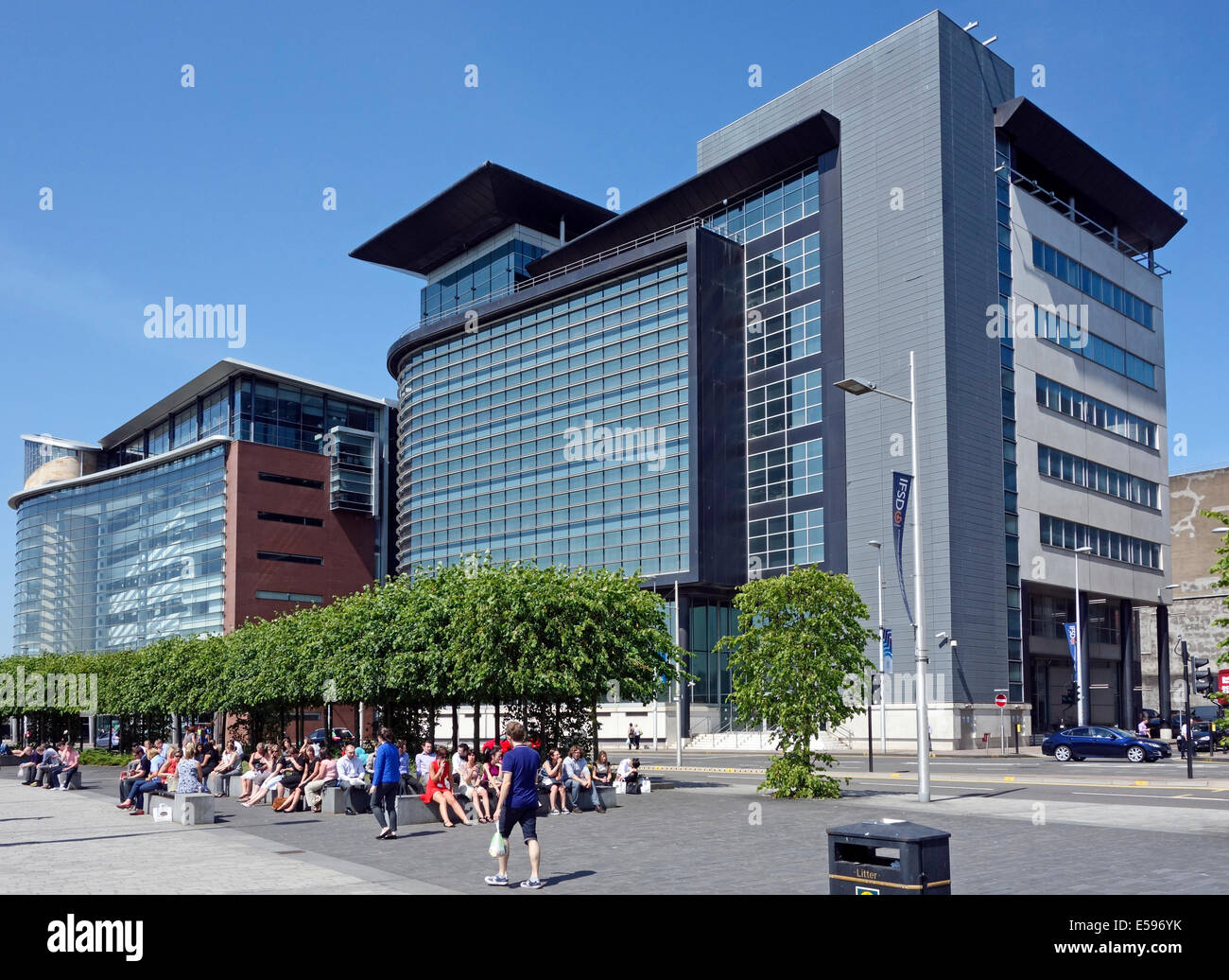 Visitors and workers sunning themselves at Broomielaw buildings on Atlantic Quay on the River Clyde in central Glasgow Scotland Stock Photo